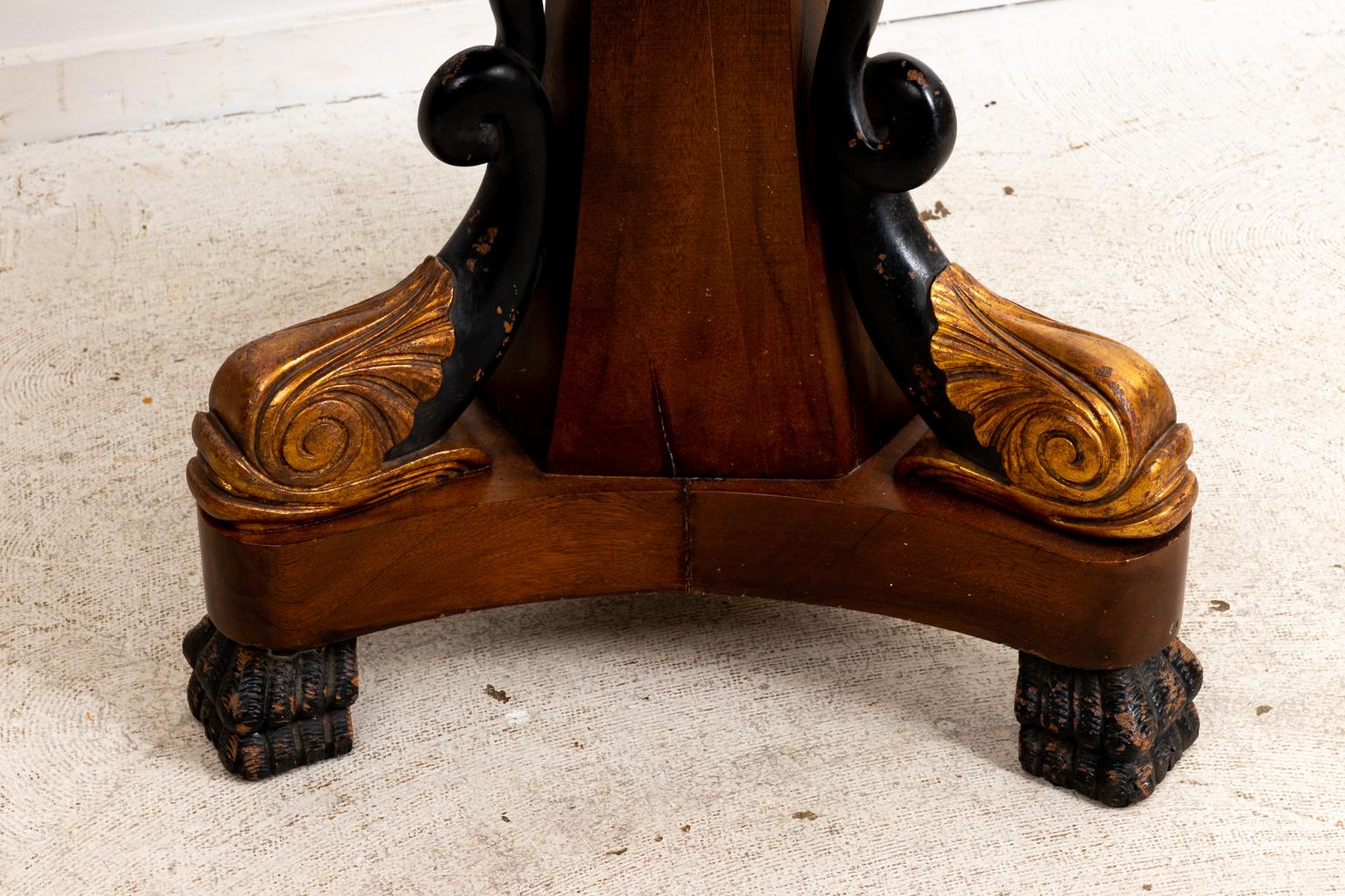 Neoclassical style round table with pedestal tripod base. The table is further detailed with carved Spanish scroll shaped feet and scrolled foliage motifs. Please note of wear consistent with age including finish loss and patina.
