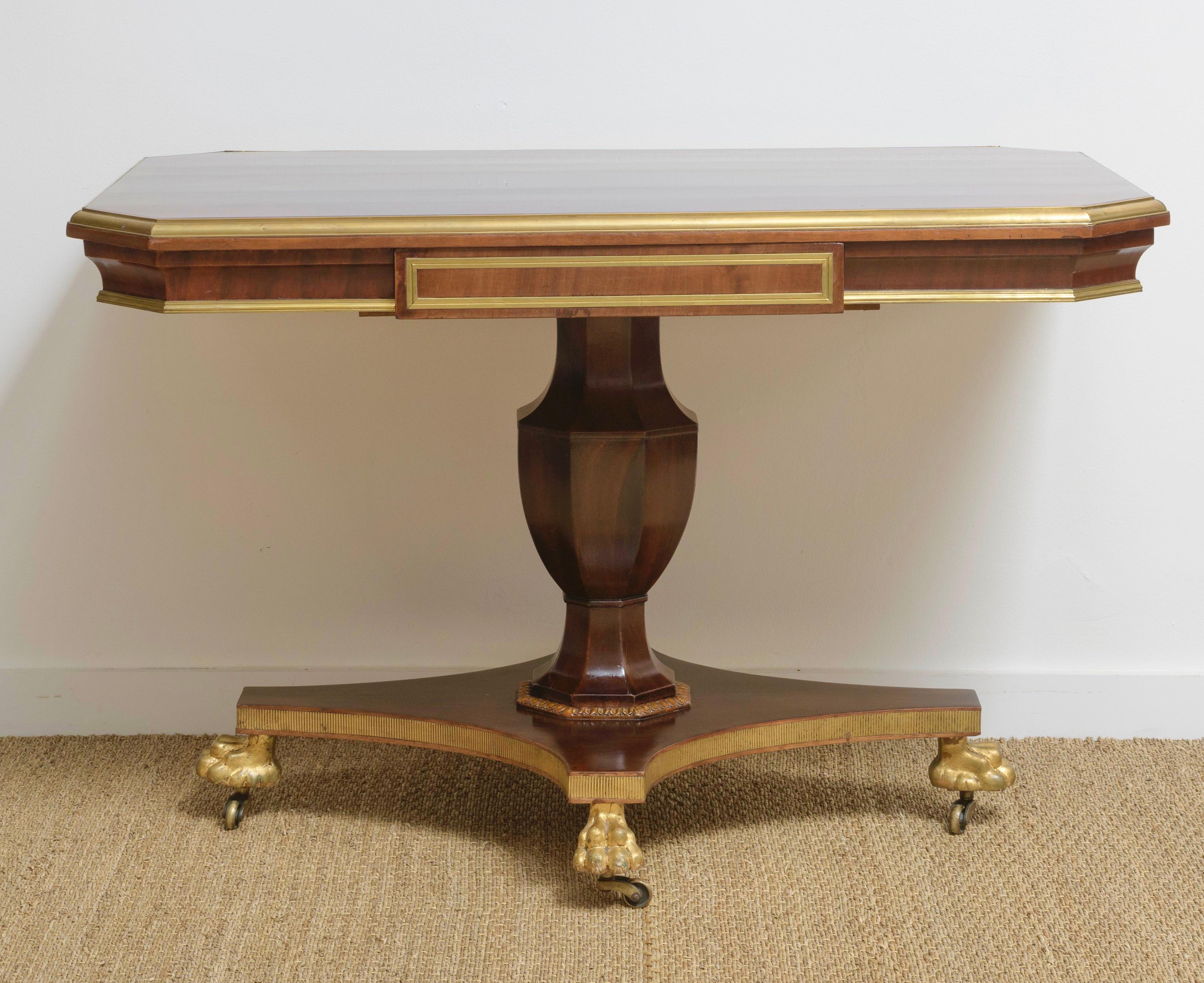 Fine 19th Century Russian Mahogany and Gilt Brass Pedestal Base Library Table.  Beautiful mahogany veneers and brass mounts.  One drawer.  Urn pedestal  resting on base with hairy paw gilded feet on wheels.   Highly decorative. 