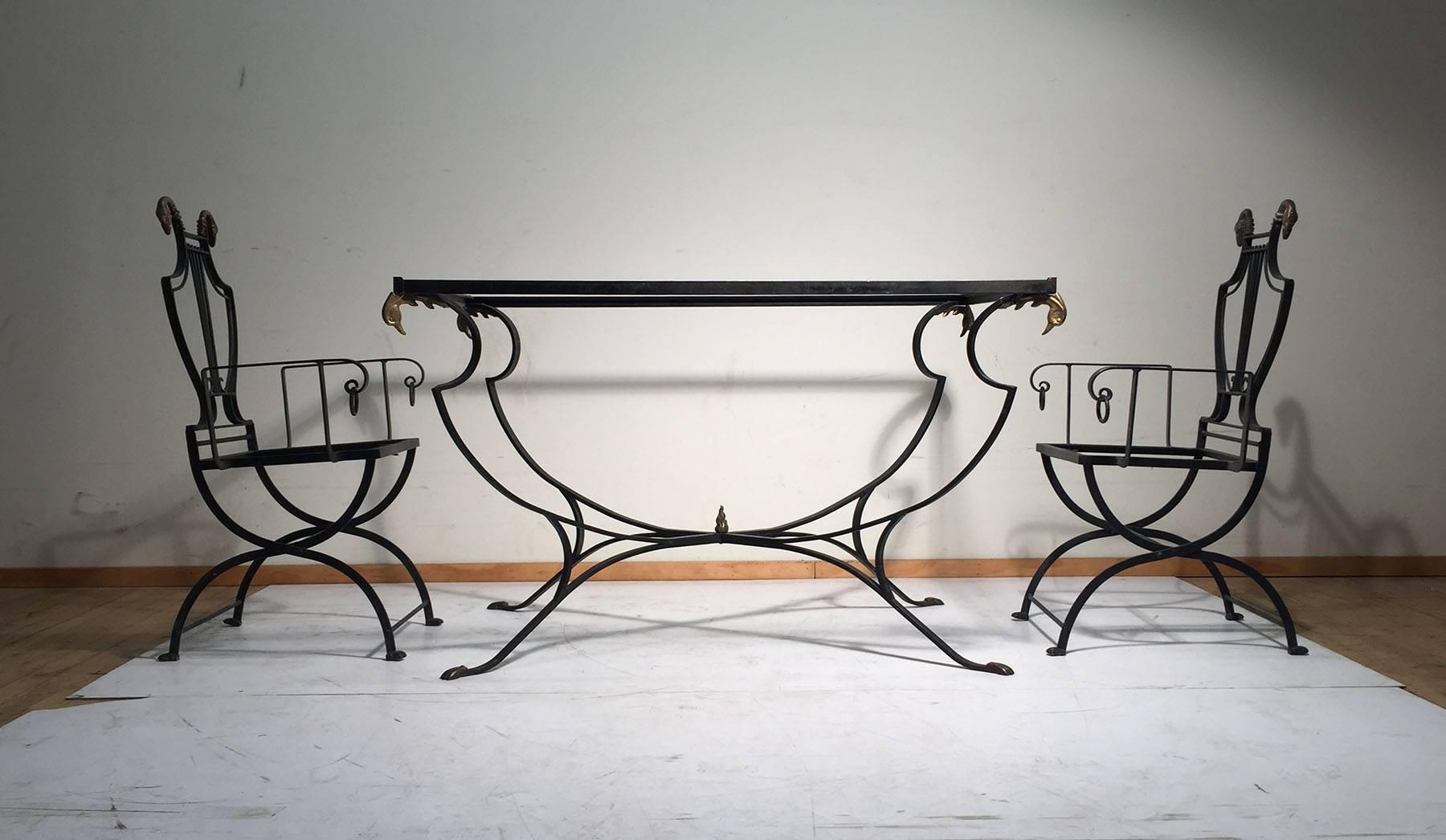 Beautiful vintage set of wrought iron garden furniture with brass swan adornments. 

This set includes three armchairs, three side chairs, one garden table. The table is very dramatic and stands on it's own. Style of Salterini, Gilbert Poillerat And
