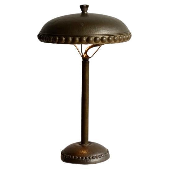 An early 20th century Amsterdam school hammered brass desk lamp in a Neoclassical Secessionist style. 

This lamp was once owned by Marten Talens, who was the owner and director of Royal Talens from Apeldoorn in the early 1900s. The lamp stood on a