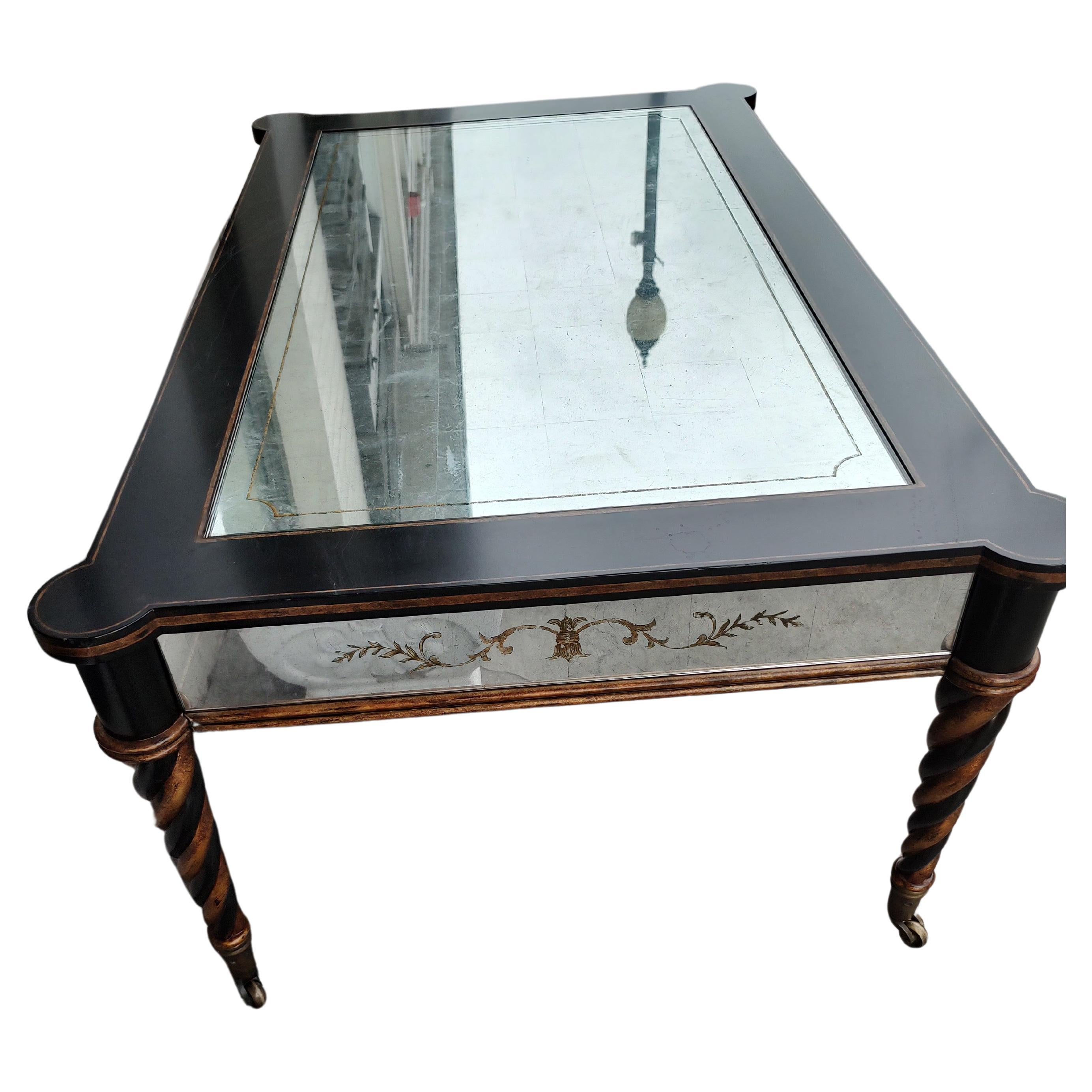 Fabulosa mesa de cóctel de estilo Sheraton con patas de columna giratoria asentadas sobre ruedas de latón macizo. Eglomise Paneles espejados en todos los delantales con un gran panel centrado en la parte superior. Marco lacado en negro con dorado en