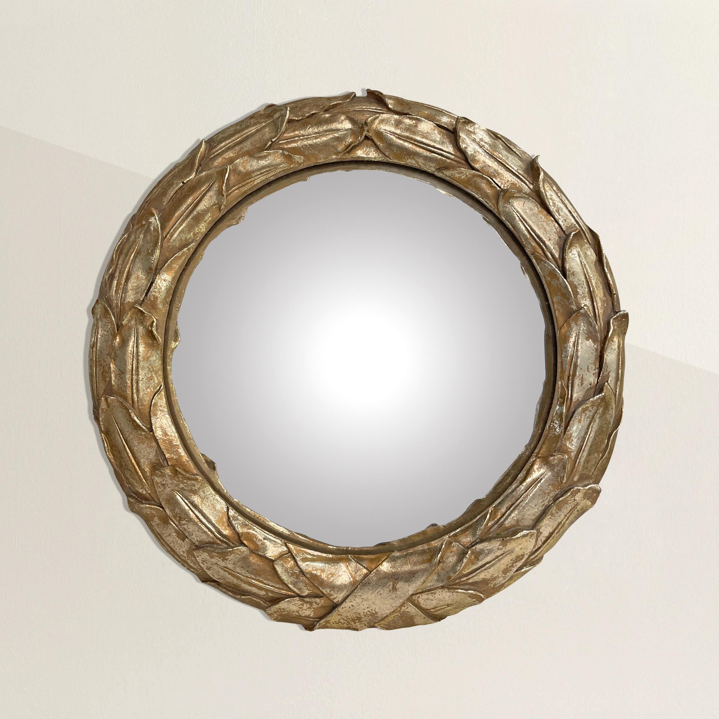 A bold neoclassical-inspired convex mirror with a laurel leaf and ribbon design, and a shimmery silver-leaf finish. The perfect mirror for a small powder room, bedroom, and just to add a little sparkle to any nook in your home.