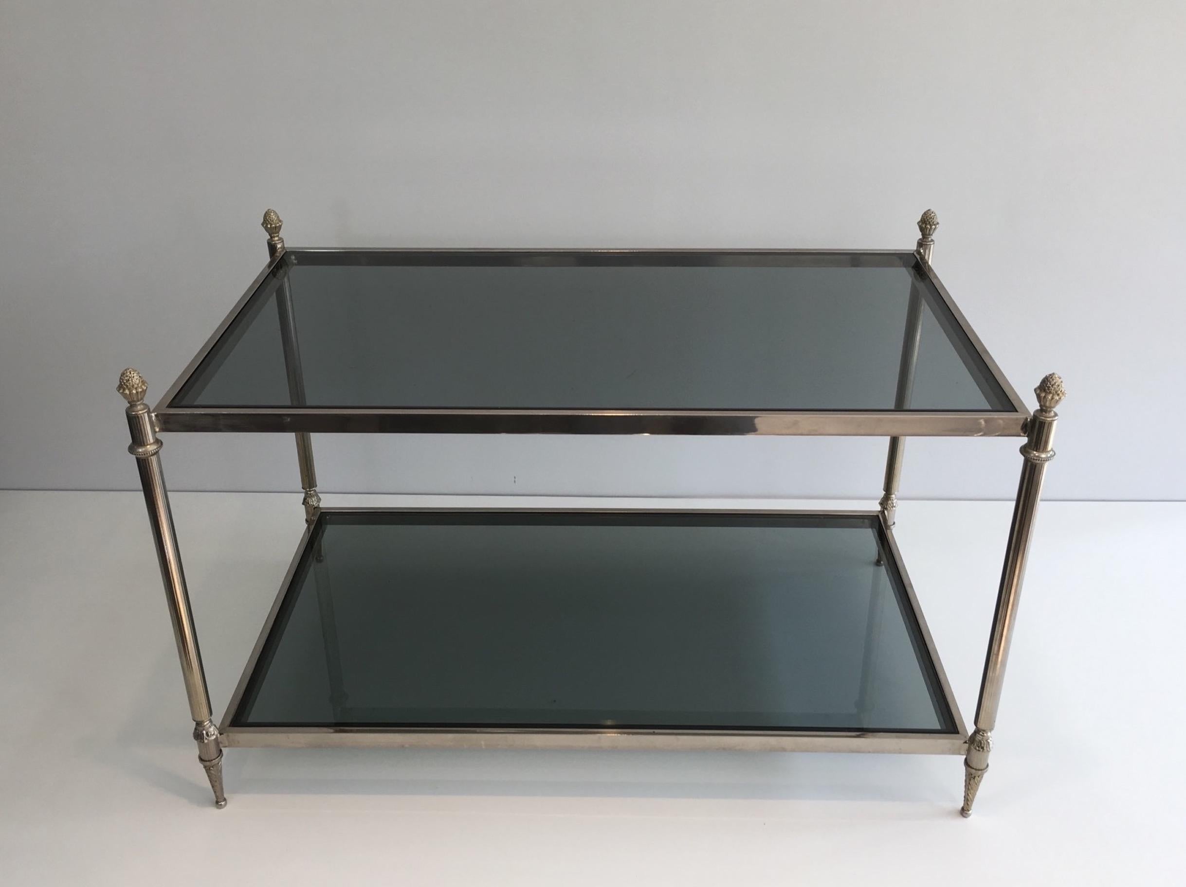 This neoclassical coffee table is made of silvered metal with blueish glass shelves. This is a French work, in the style of Maison Jansen, circa 1940.