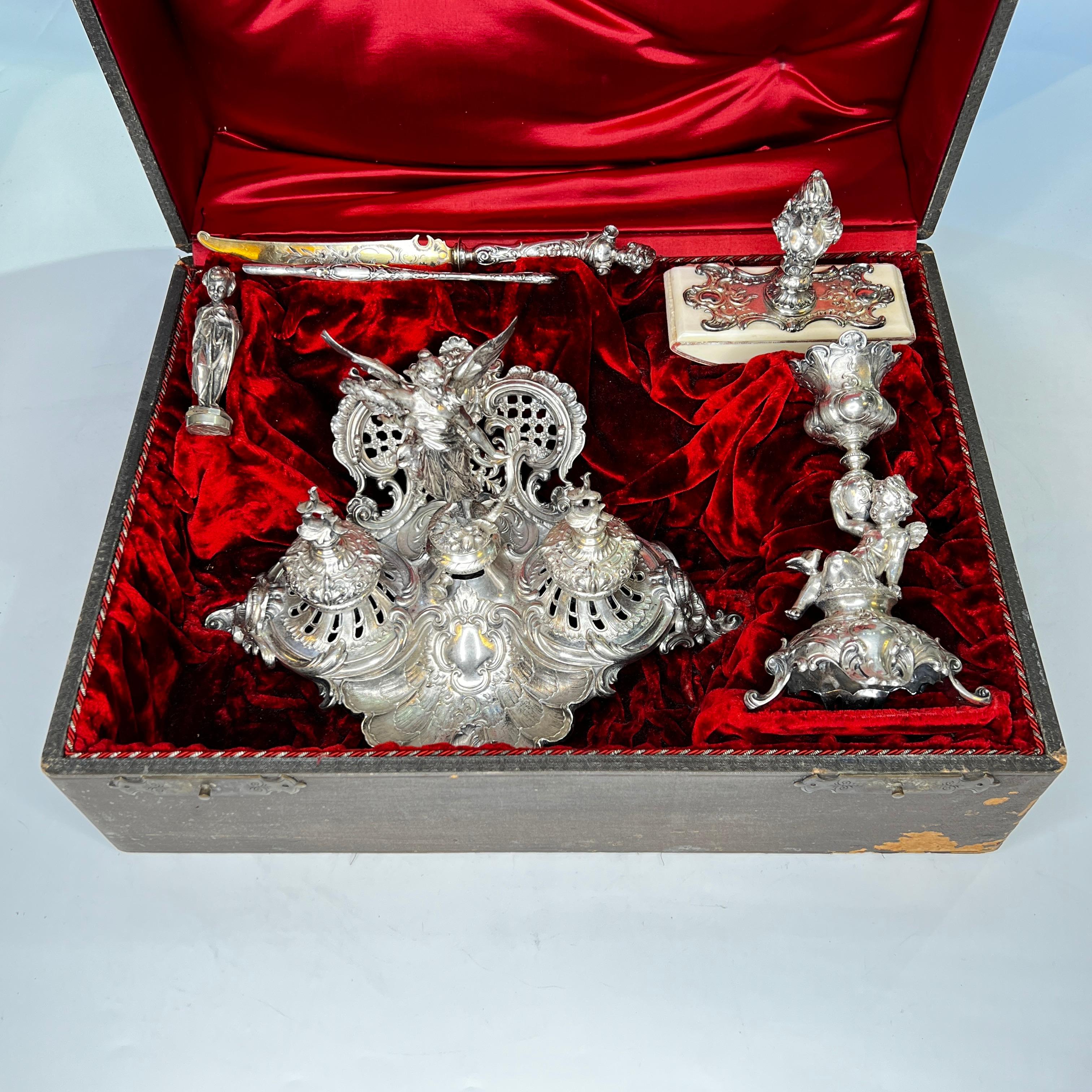 Our exceptional nineteenth century writing set from the Greek Revival period of the nineteenth century includes its original satin-lined gift case, inkwell depicting Nike, the Greek goddess of victory, ink blotter, pen, letter opener, candlestick