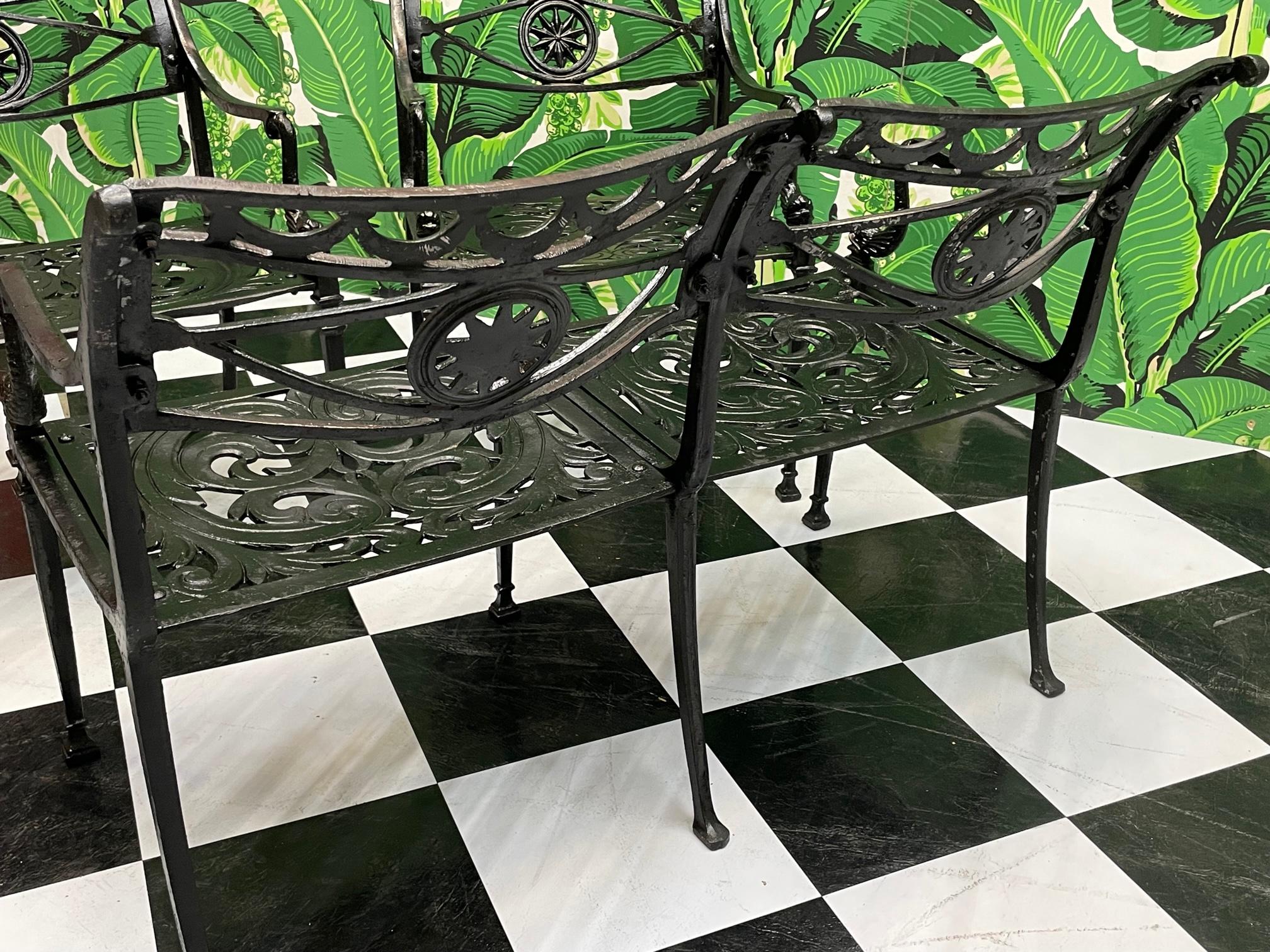 Star and dolphin motif patio bench in cast aluminum. Neoclassic style with fabric swags, acanthus leaf seat, coupled with Asian influence dolphins as arm supports. Good condition with imperfections consistent with age, structurally sound, see photos