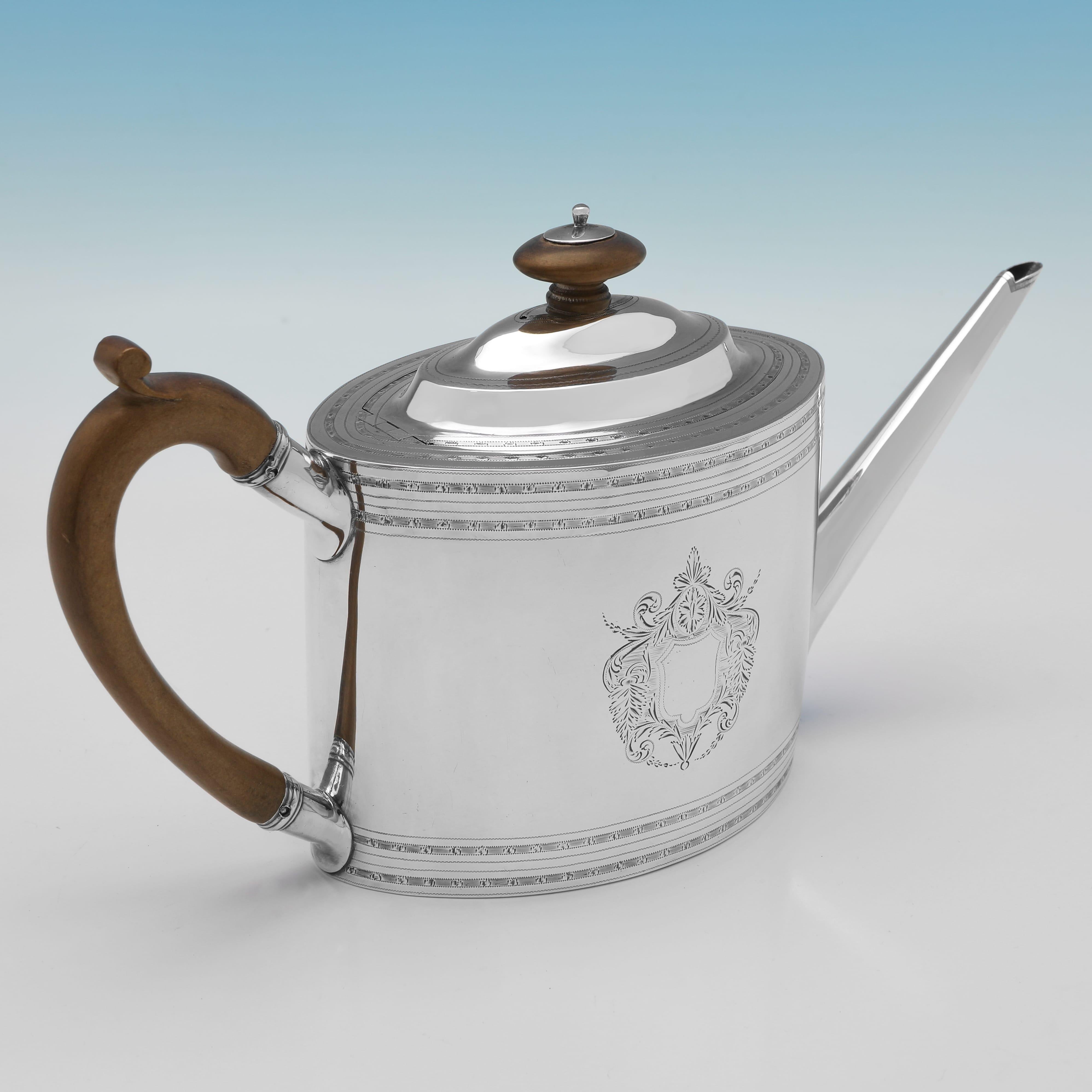 Hallmarked in London in 1796 by Alexander Field, this very handsome, George III period, Antique Sterling Silver Teapot, features bands of engraving, a vacant cartouche, and a wooden handle and finial. 

The teapot measures 6.5