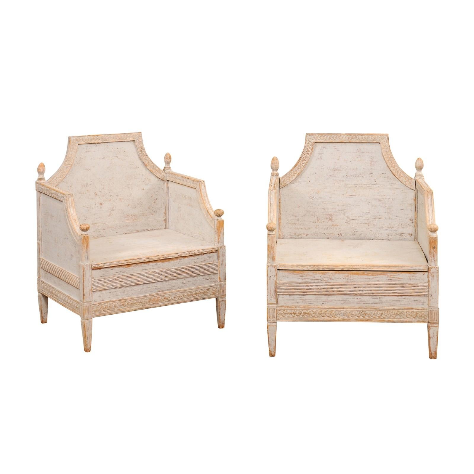 A pair of Swedish Neoclassical style wooden armchairs from circa 1850 with carved guilloche friezes, Classic light gray painted finish and carved finials. These exquisite Swedish Neoclassical style wooden armchairs, dating back to approximately