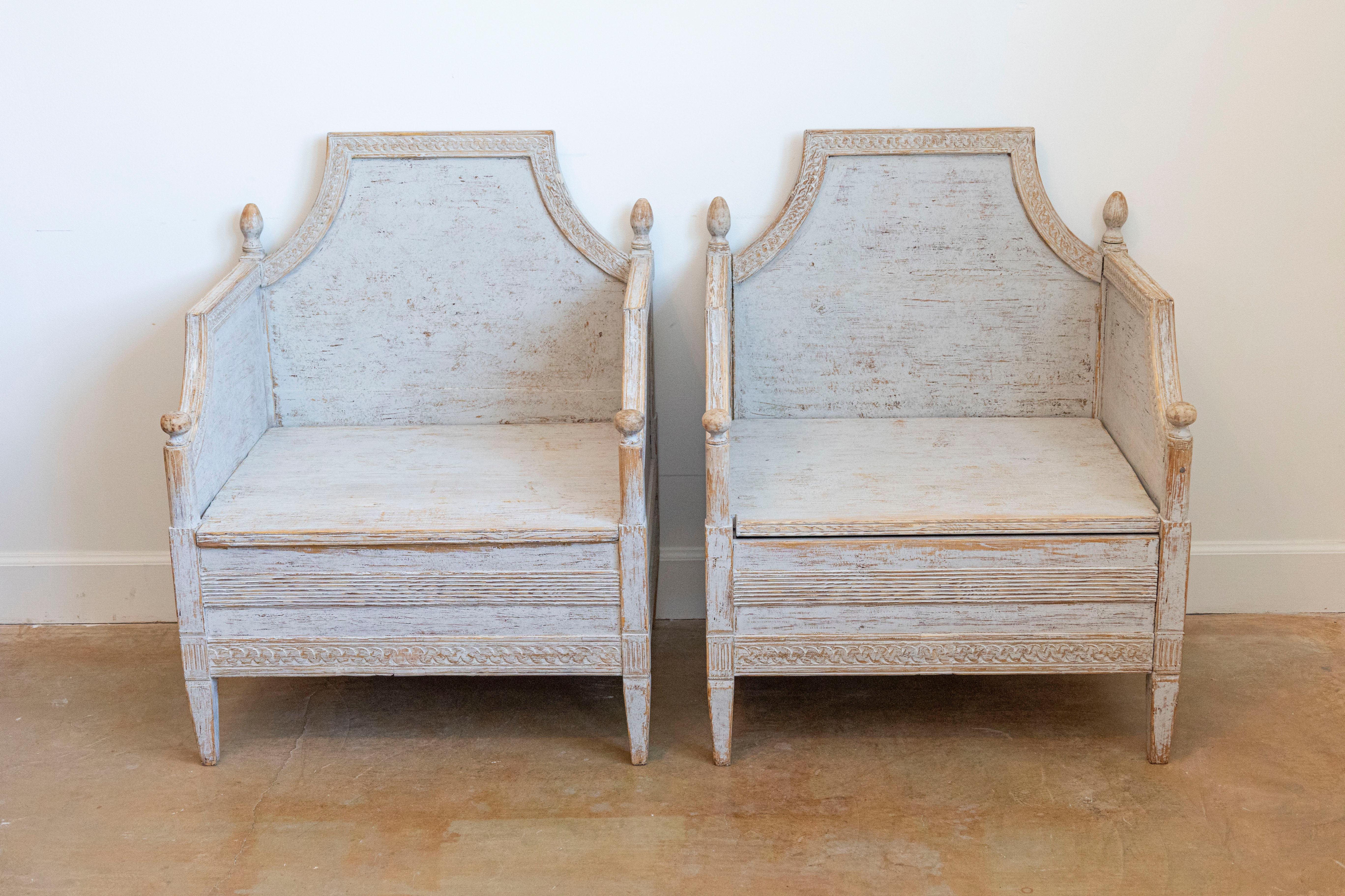 Paire de fauteuils en bois de style néoclassique suédois, datant d'environ 1850, avec frises guillochées sculptées, finition classique peinte en gris clair et épis de faîtage sculptés. Ces exquis fauteuils en bois de style néoclassique suédois,