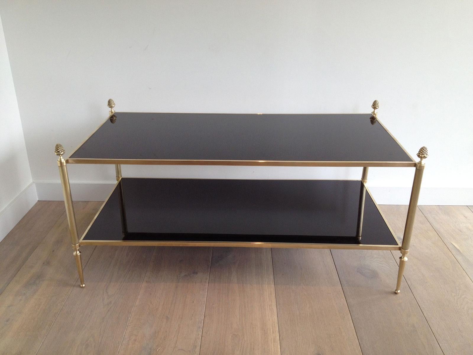 This beautiful and rare neoclassical style 2 tiers coffee table is made of brass and bronze with black lacquered glass shelves. This is a French work by Maison Baguès. Circa 1940