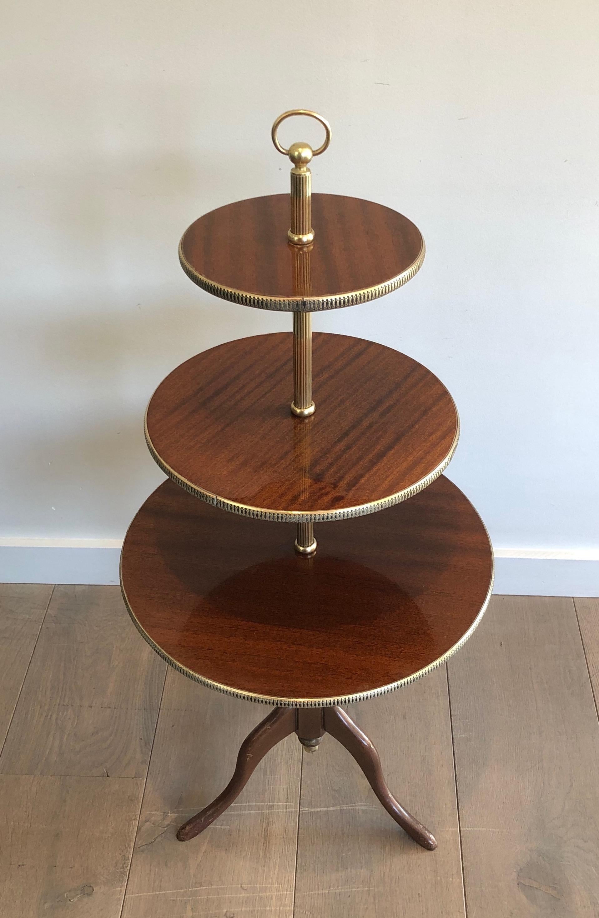 This neoclassical style 3 tiers serving table is made of mahogany and brass. This is a French work, circa 1940.
