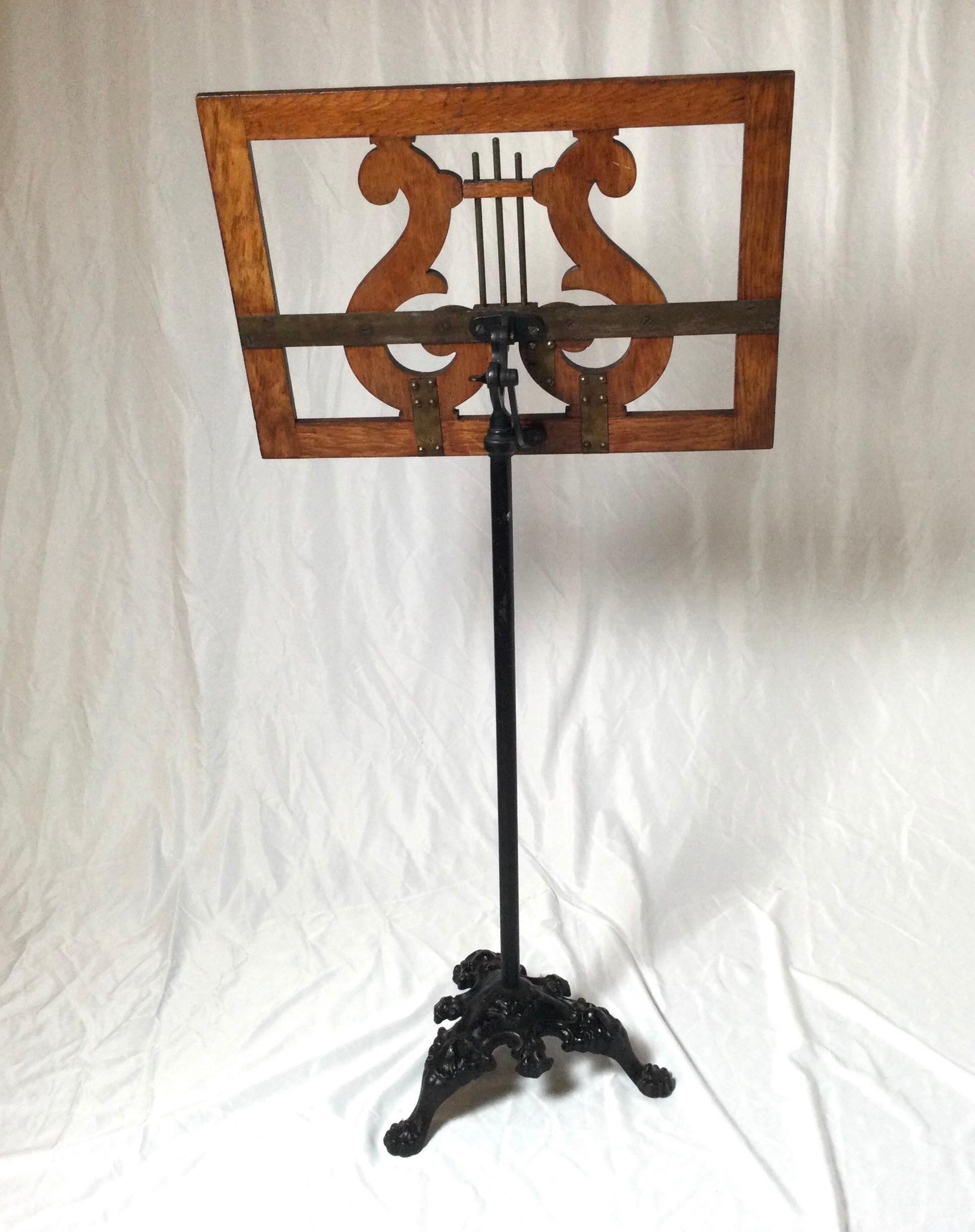 Neoclassical style adjustable oak and metal music stand. It adjusts up to about 64