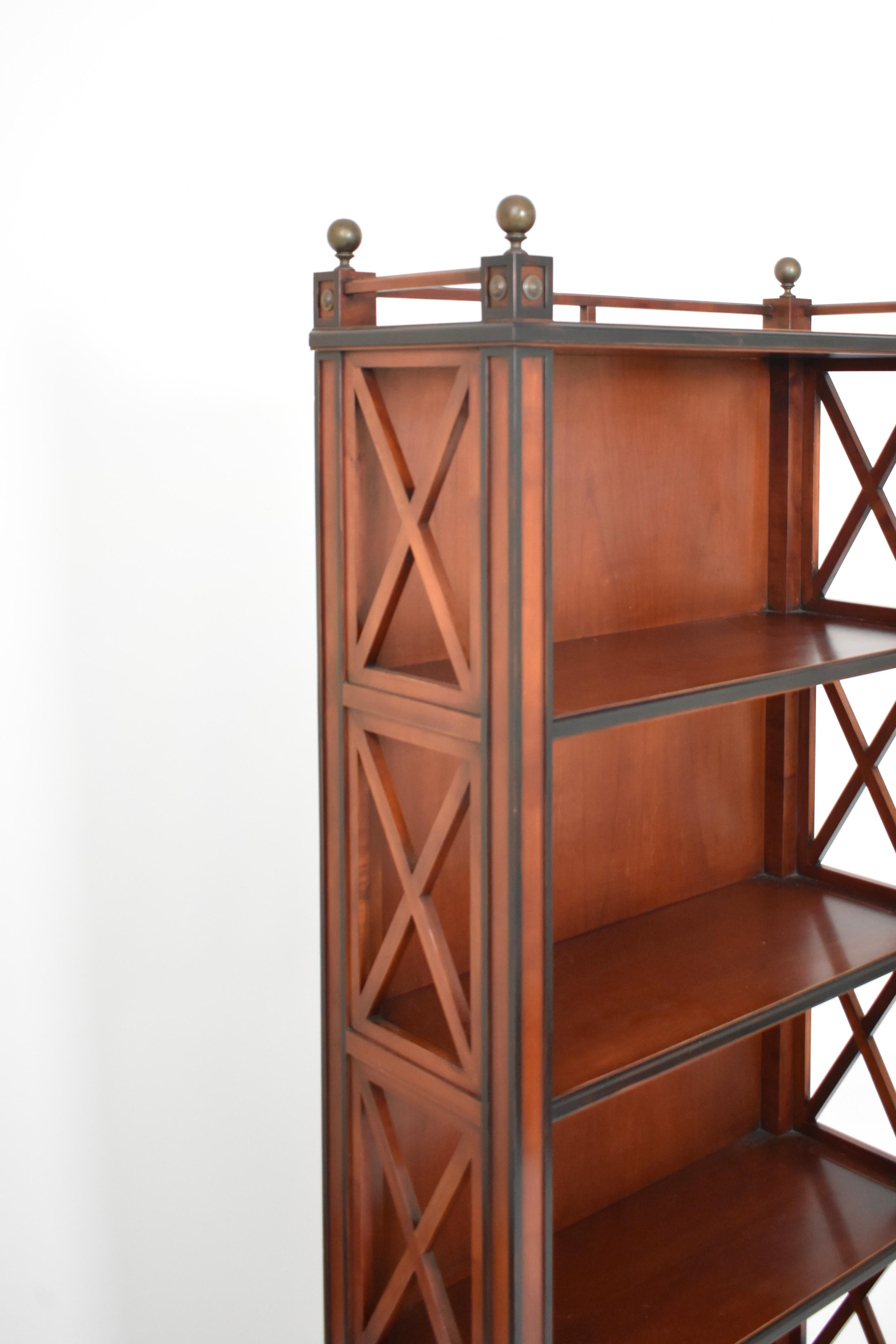 Libreria in stile neoclassico in legno tinto mogano, legno annerito e ottone patinato con quattro ripiani, piano a galleria, lati a traliccio. Lavoro da decoratore. Francia, anni '80.
