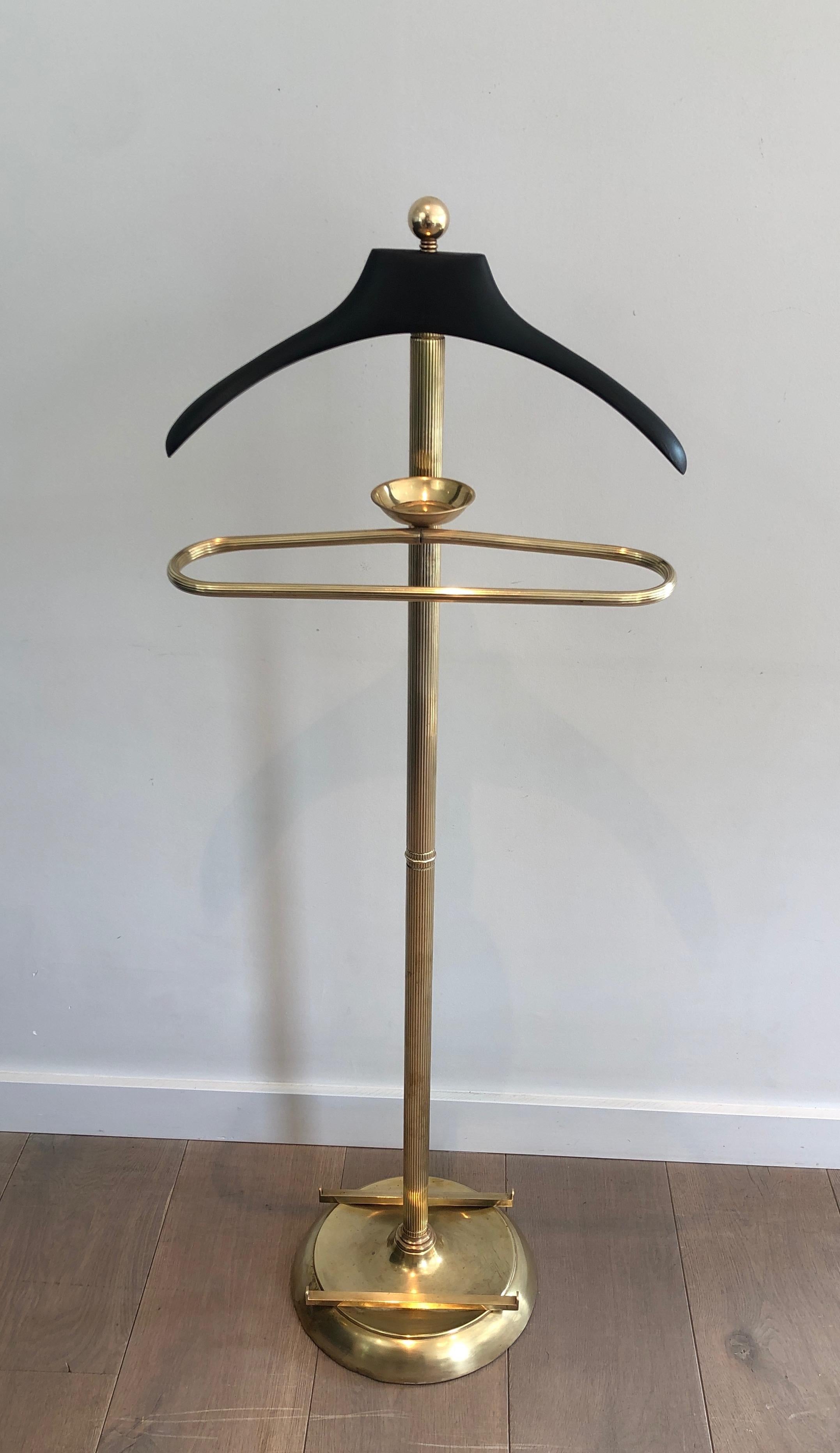 This neoclassical style valet is made of brass and black lacquered wood. This is a French work, circa 1940.