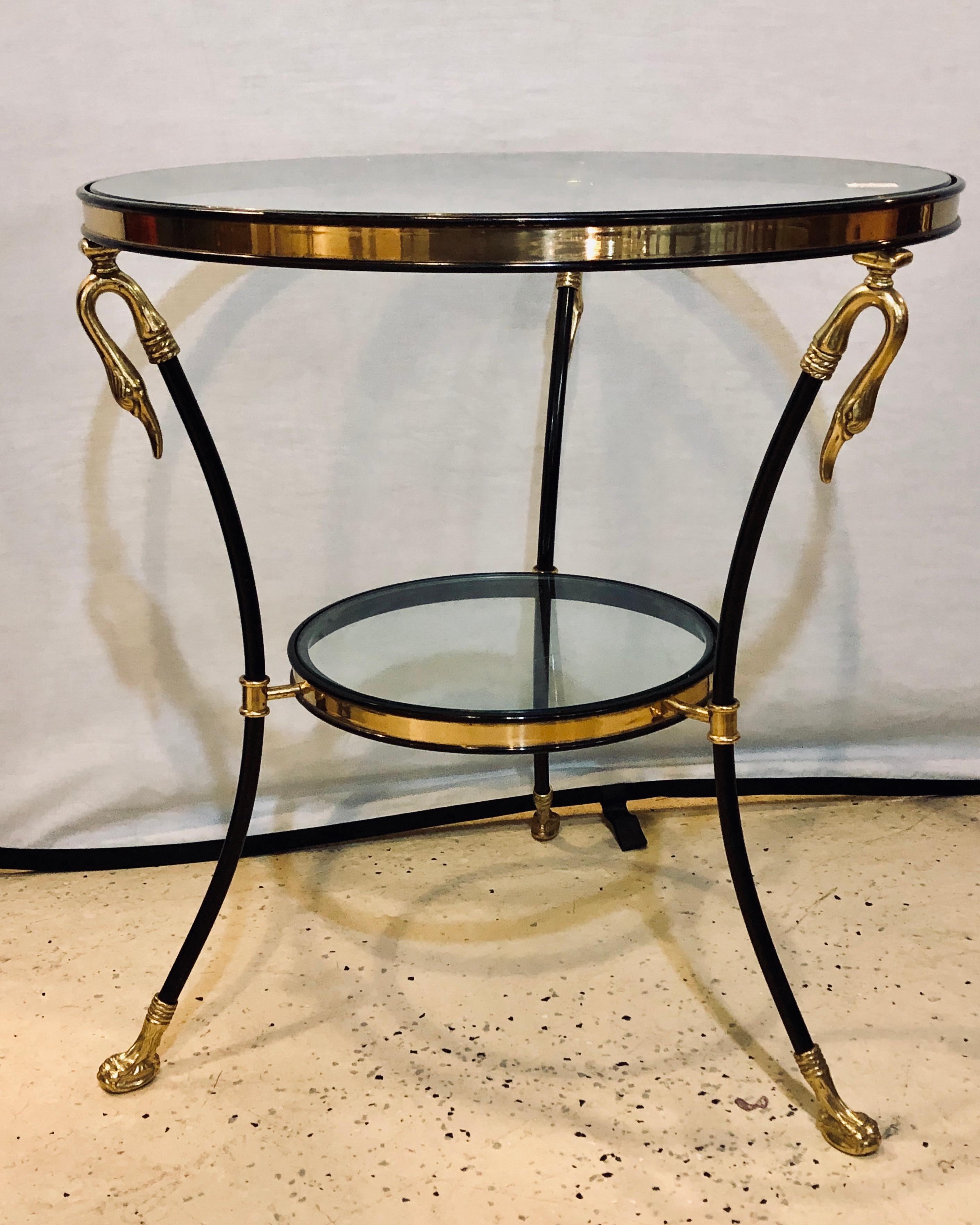 A fine custom quality neoclassical style brass and ebony steel bouilliotte / center or end table with swan heads. This Hollywood Regency end or bouilliotte table is seemingly timeless in fashion and design. The overall brass claw feet leading to
