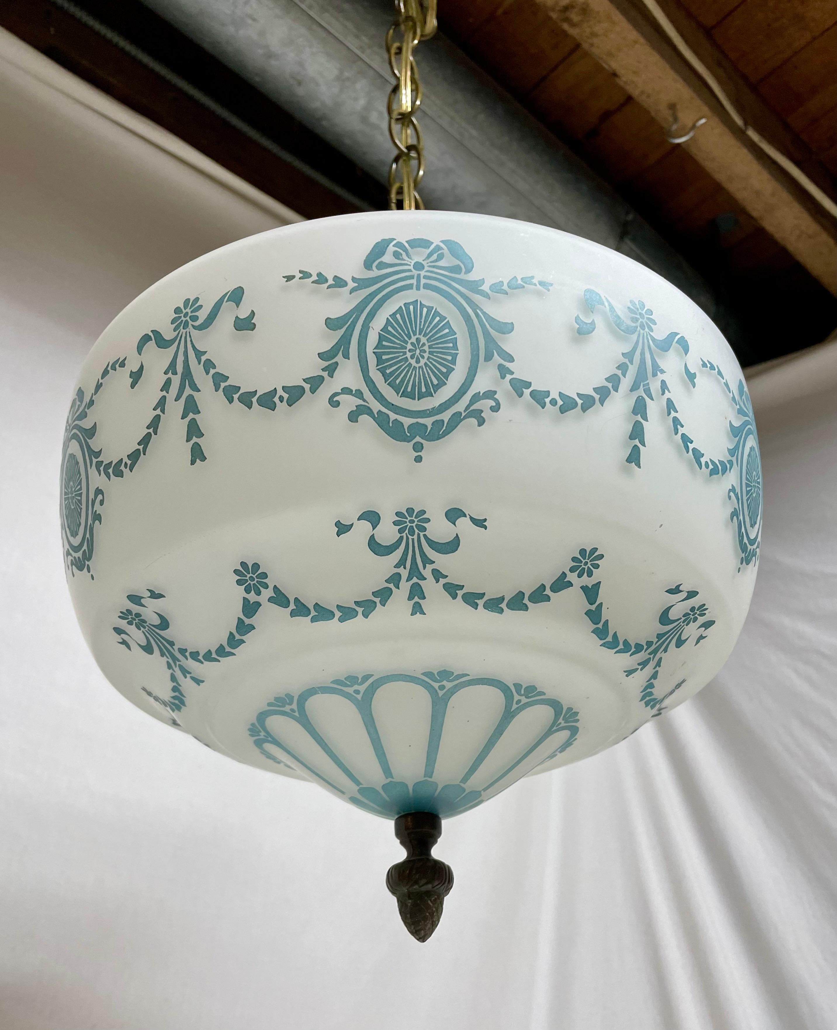 Lampada a sospensione in ottone antico e vetro in stile neoclassico del 1940 con fiocchi e volute dipinte. Terminale in ottone sul fondo. 42
