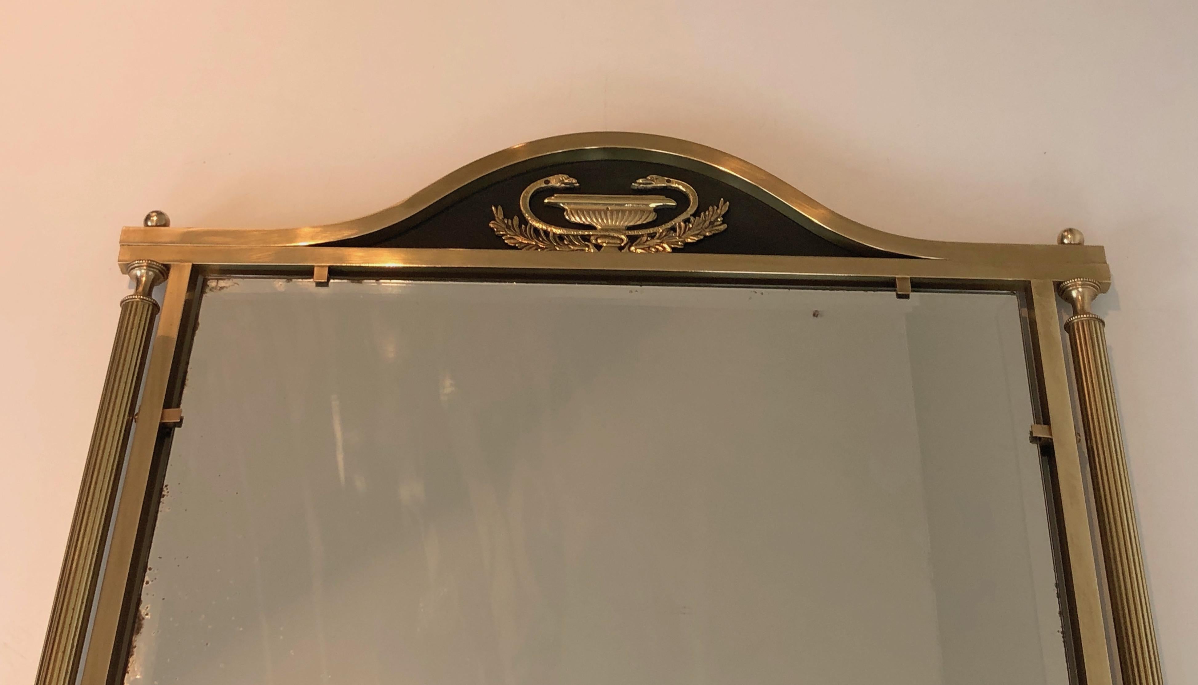 Dieser Spiegel im Empire-Stil ist aus Messing und lackiertem Metall mit Dekoration. Es handelt sich um ein französisches Werk aus der Zeit um 1940.
