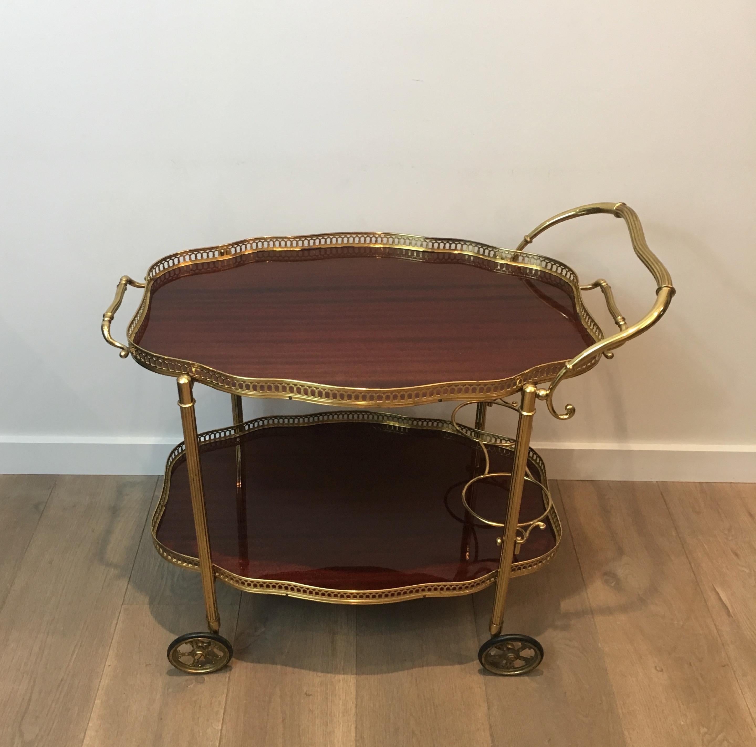 This neoclassical style bar cart is made of brass and mahogany. Both Trays of this drinks trolley are removable and can be used to serve. This is a French Work, circa 1970.