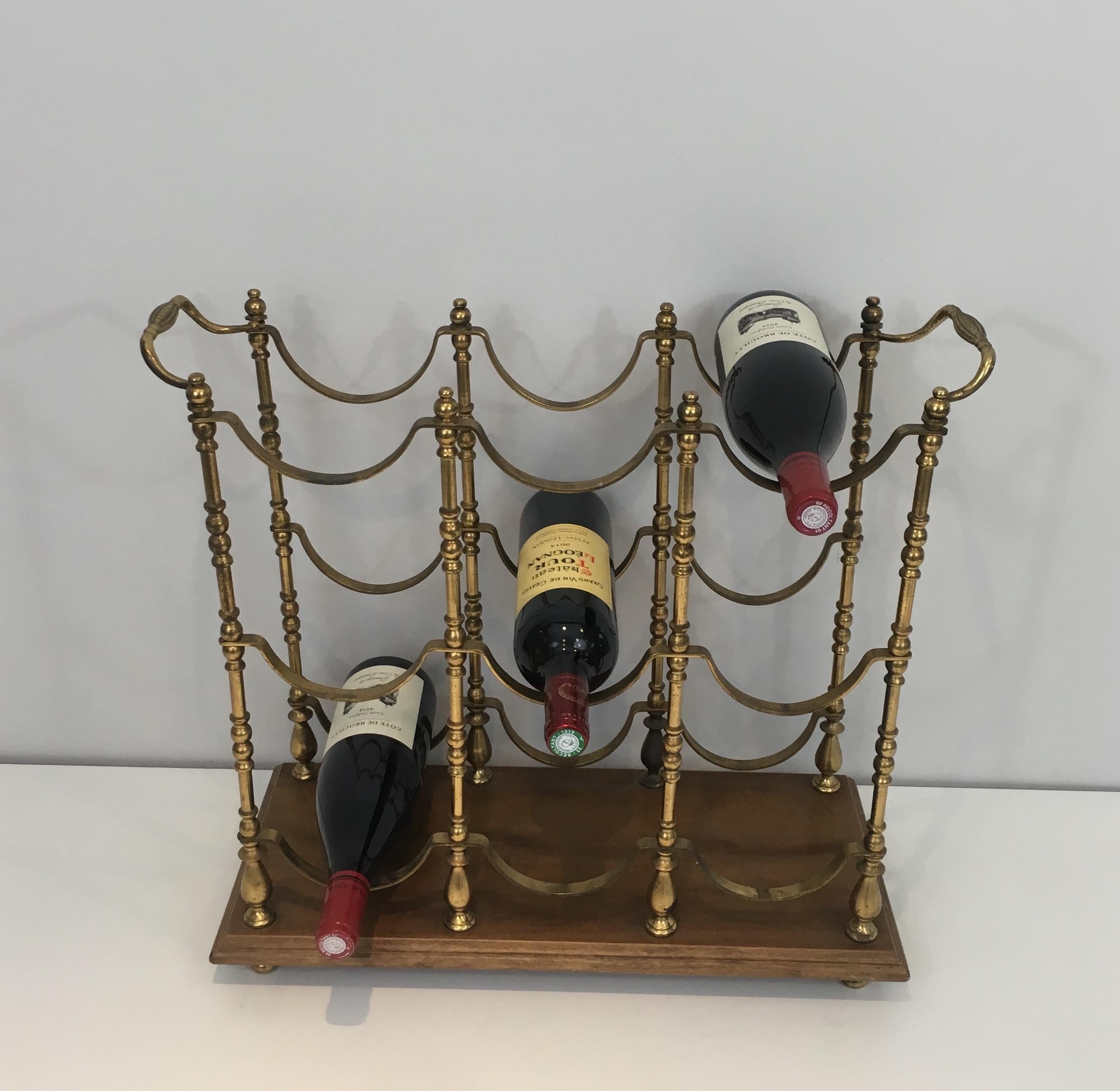 This neoclassical style bottles holder is very decorative. This is made of brass on a wooden base. This bottles rack is a French work, circa 1960.