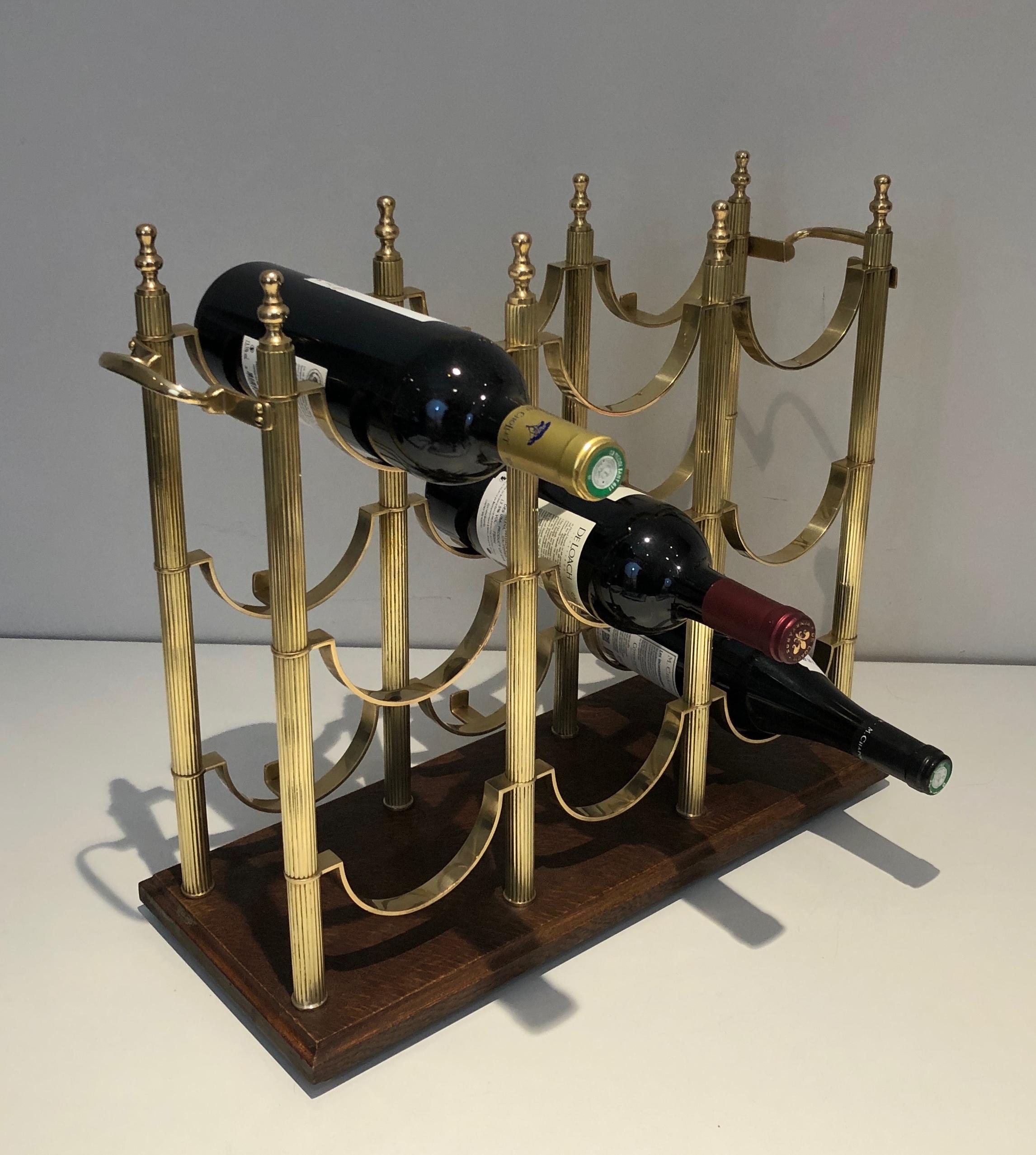 This very nice neoclassical style bottles holder is made of brass on a wooden base. This is a French work in the style of Maison Jansen. Circa 1940