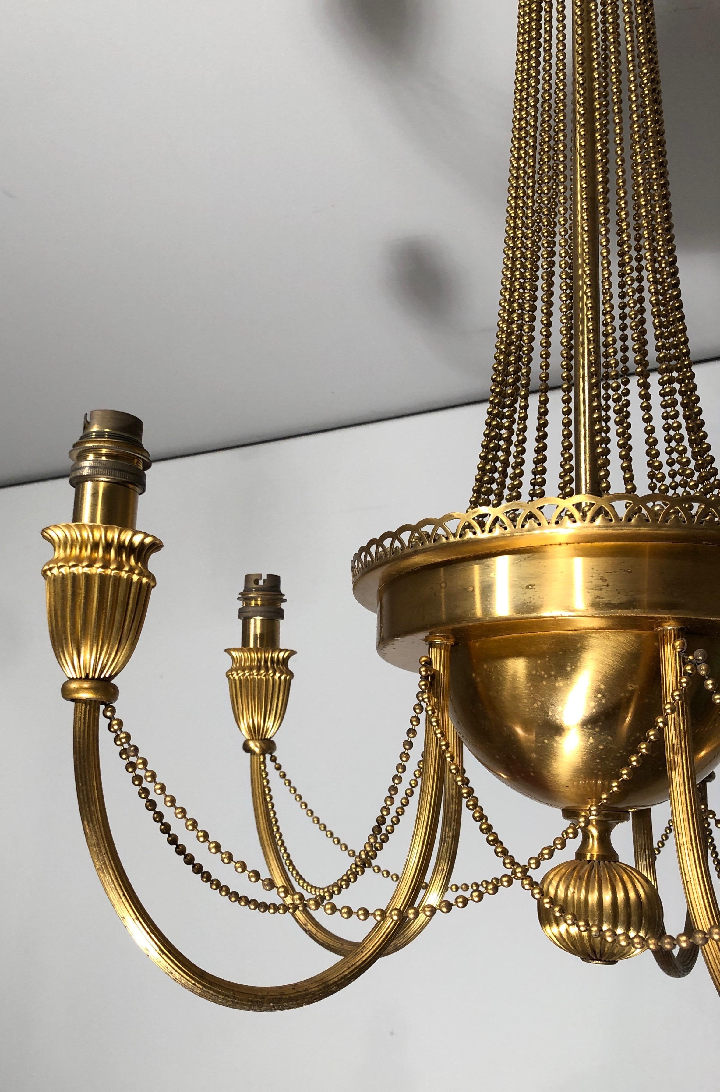 Araña de latón de estilo neoclásico decorada con guirnaldas de perlas. Obra francesa. mediados del siglo XX en venta