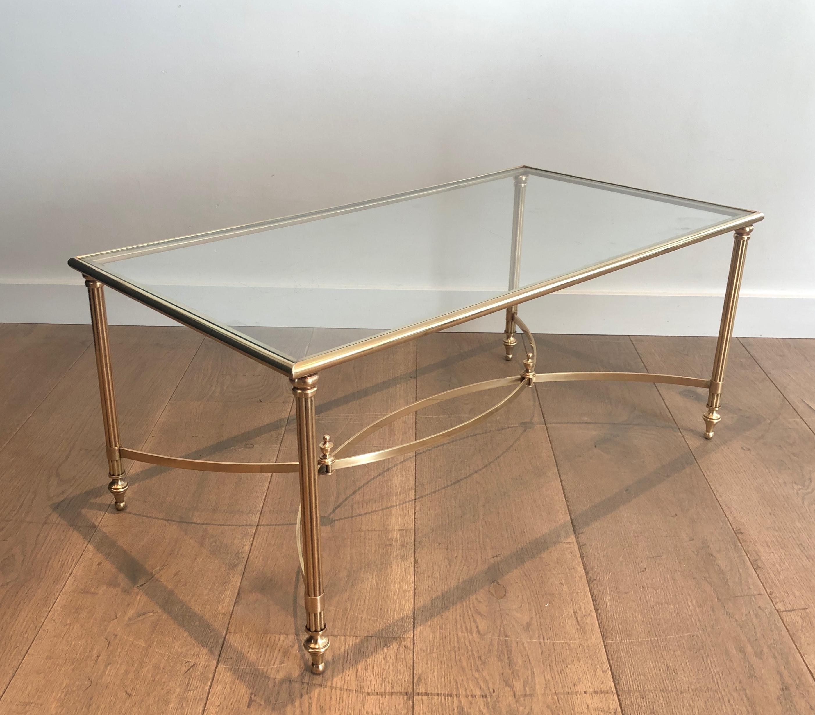 Cette très belle et élégante table basse de style néoclassique est en laiton avec une tablette en verre transparent sur le dessus. Il s'agit d'une œuvre française de la Maison Jansen. Circa 1940