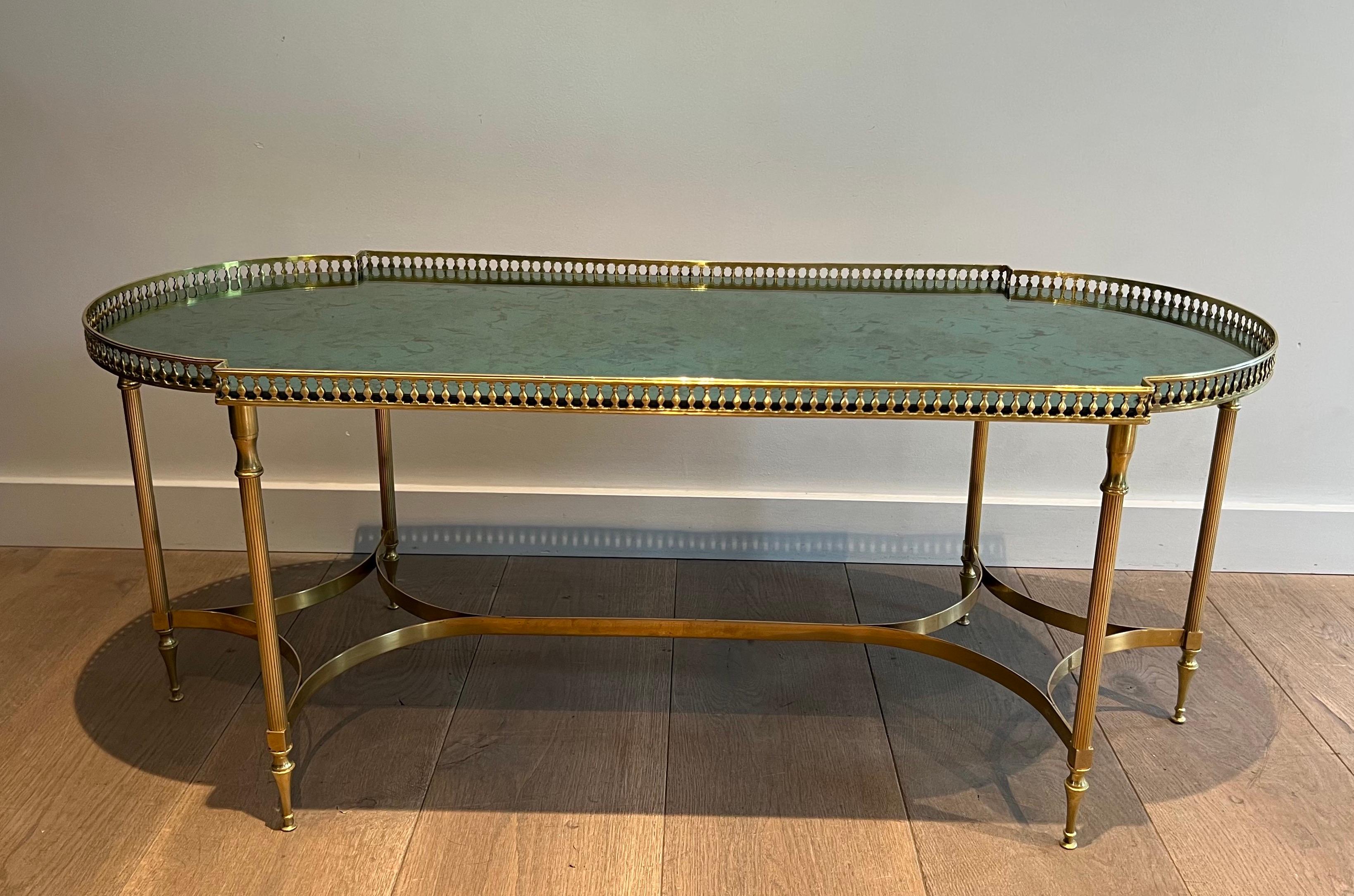 This neoclassical style coffee table is made of  brass with eglomised mirror on top. The top mirror was cut in an old mirror from the famous Opera Garnier in Paris. This is a French work in the style of Maria Pergay. Circa 1940
