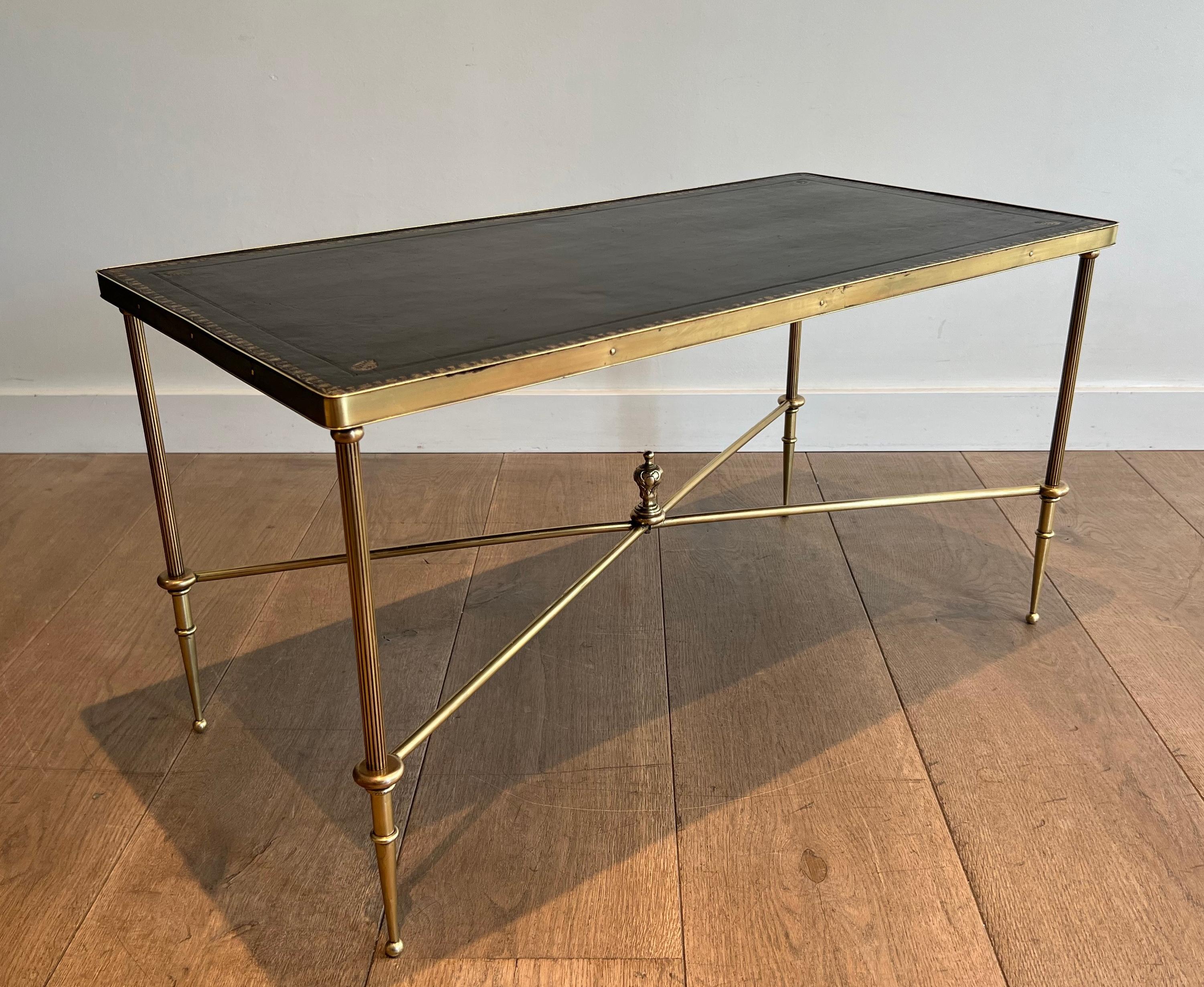 Cette table basse de style néoclassique très nie et élégante est fabriquée en laiton avec un plateau en cuir noir. Il s'agit d'un ouvrage français de la Maison Jansen. Circa 1940