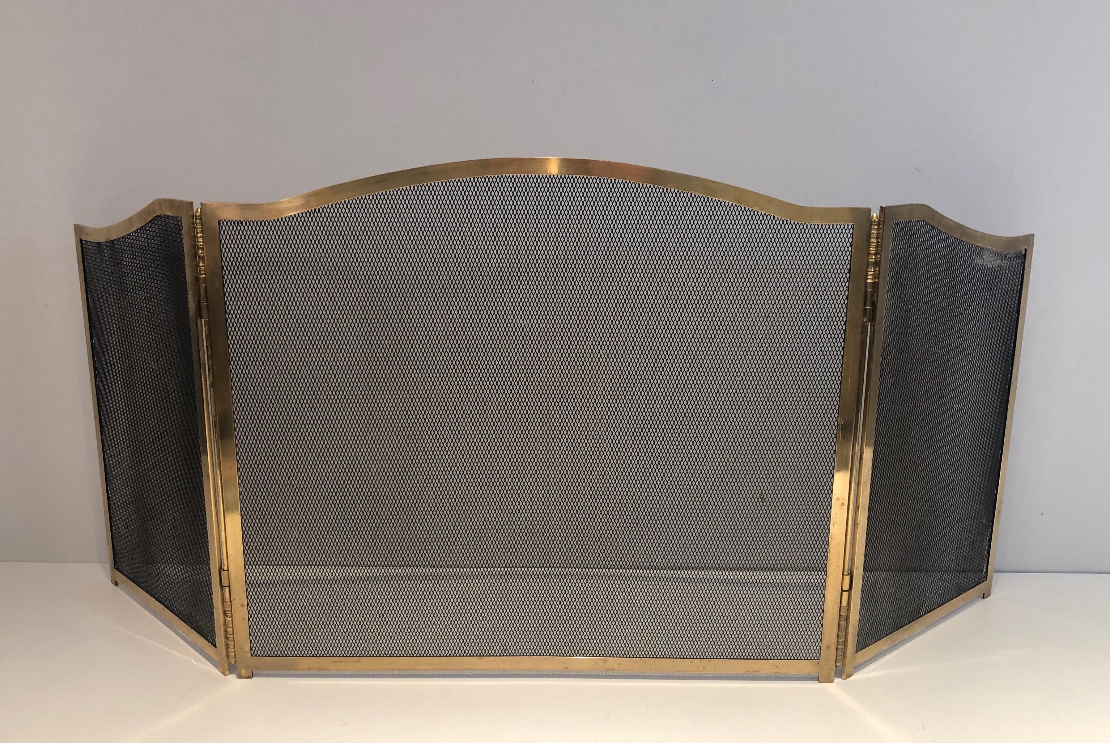 This neoclassical style fireplace screen is made of brass and grilling. This is a French work, circa 1970.