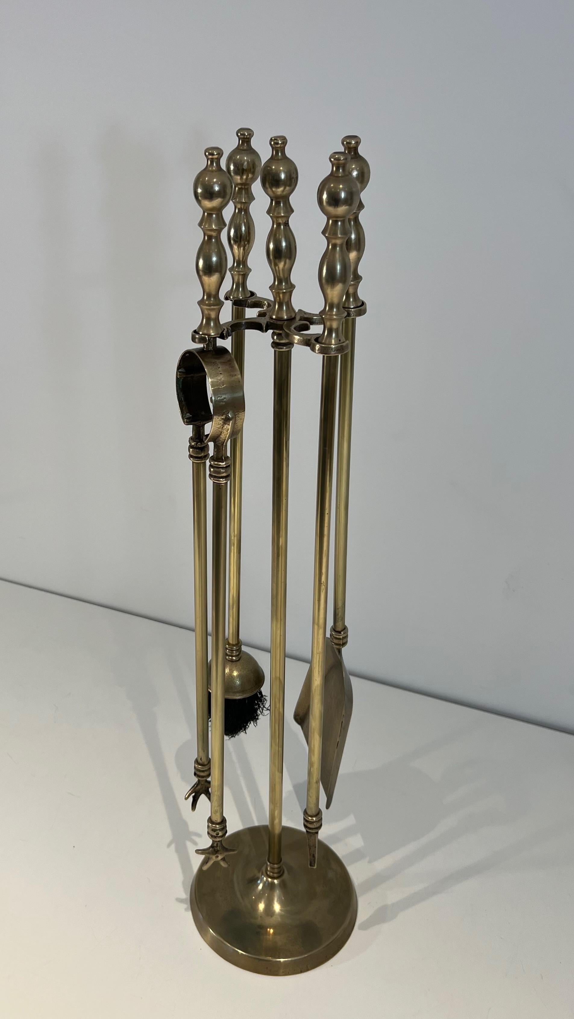 This neoclassical style fireplace tools on stand is made of brass . This si a French  work. Circa 1970