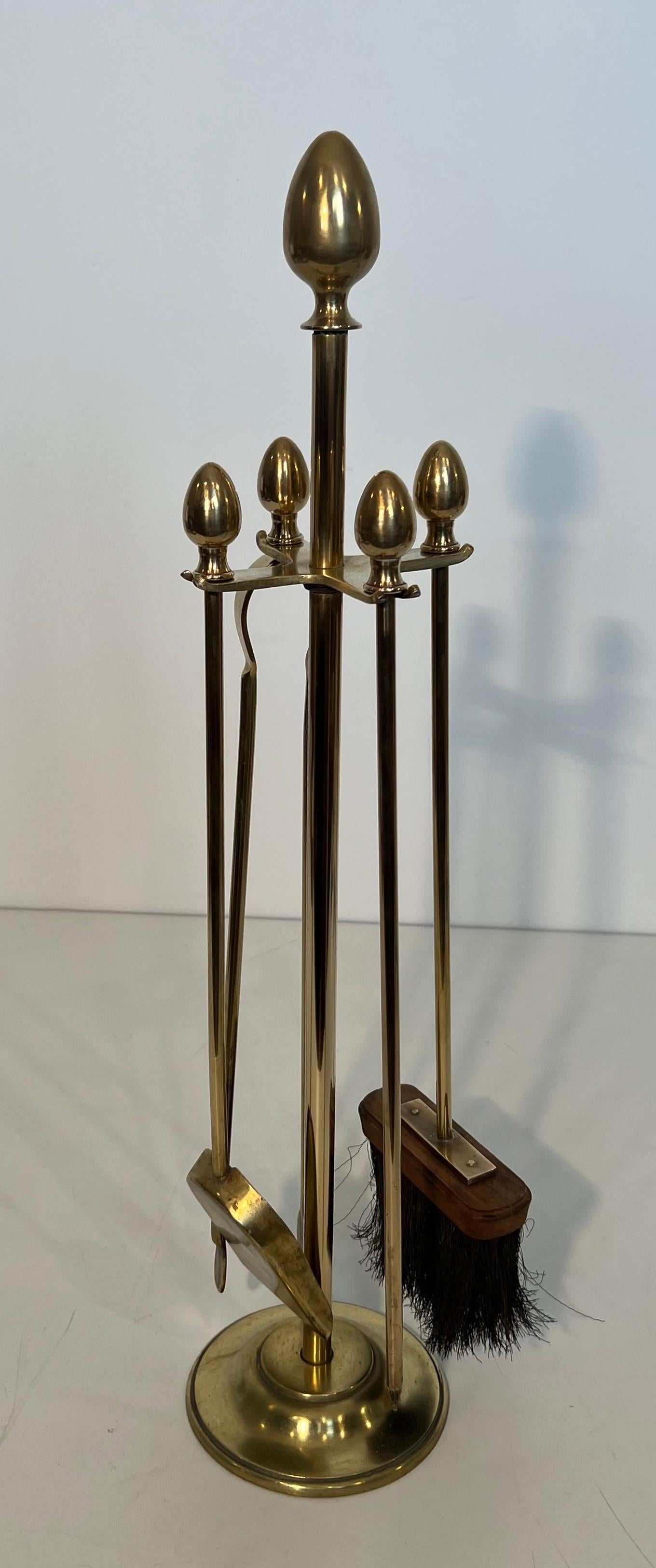 This neoclassical style fireplace tools on stand is made of brass. This is a French work in the style of Maison Jansen. Circa 1970