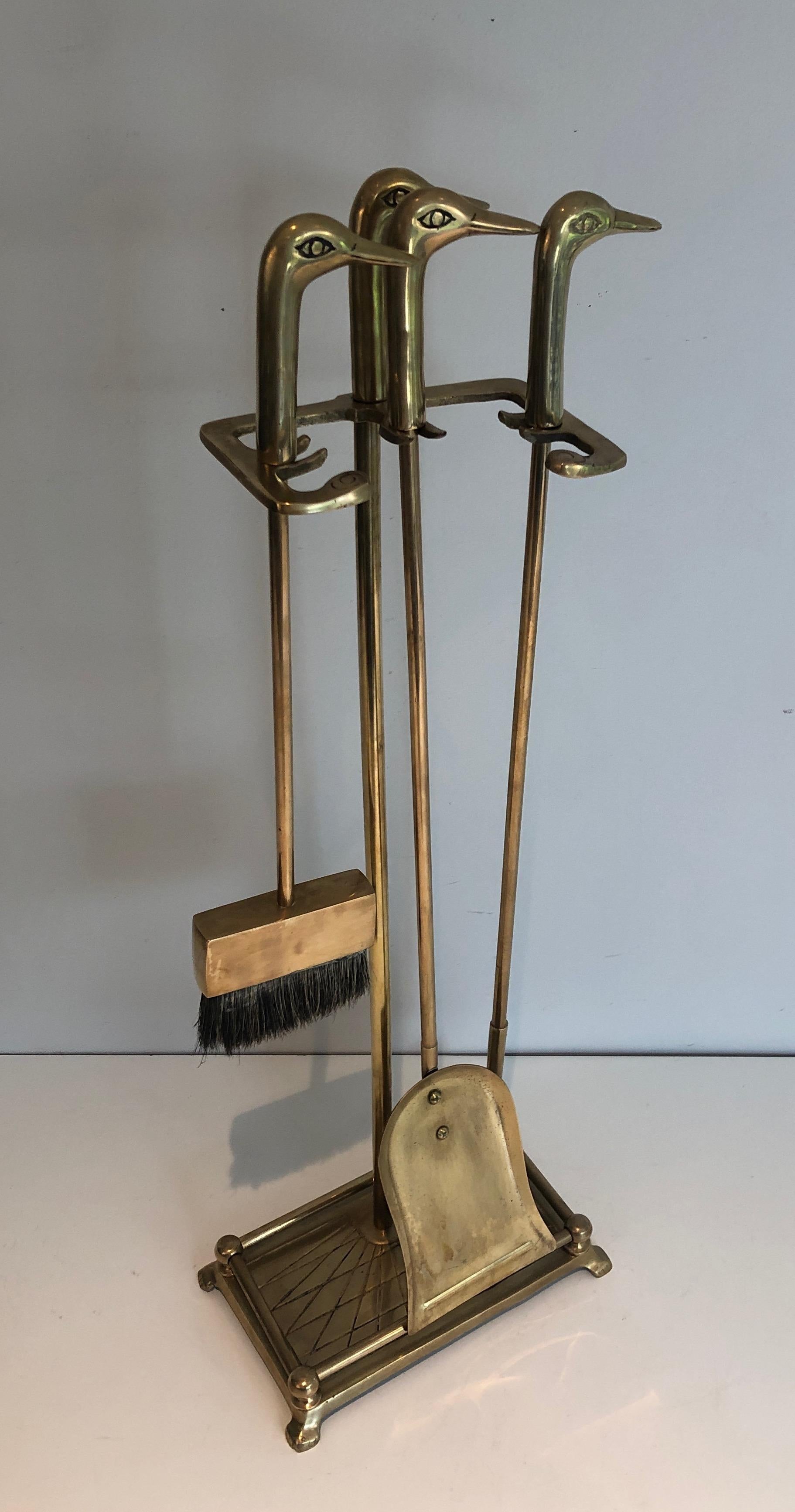 This neoclassical style fireplace tools are made of brass. Each tool's handle is showing a duck head. This is a French work. Circa 1970