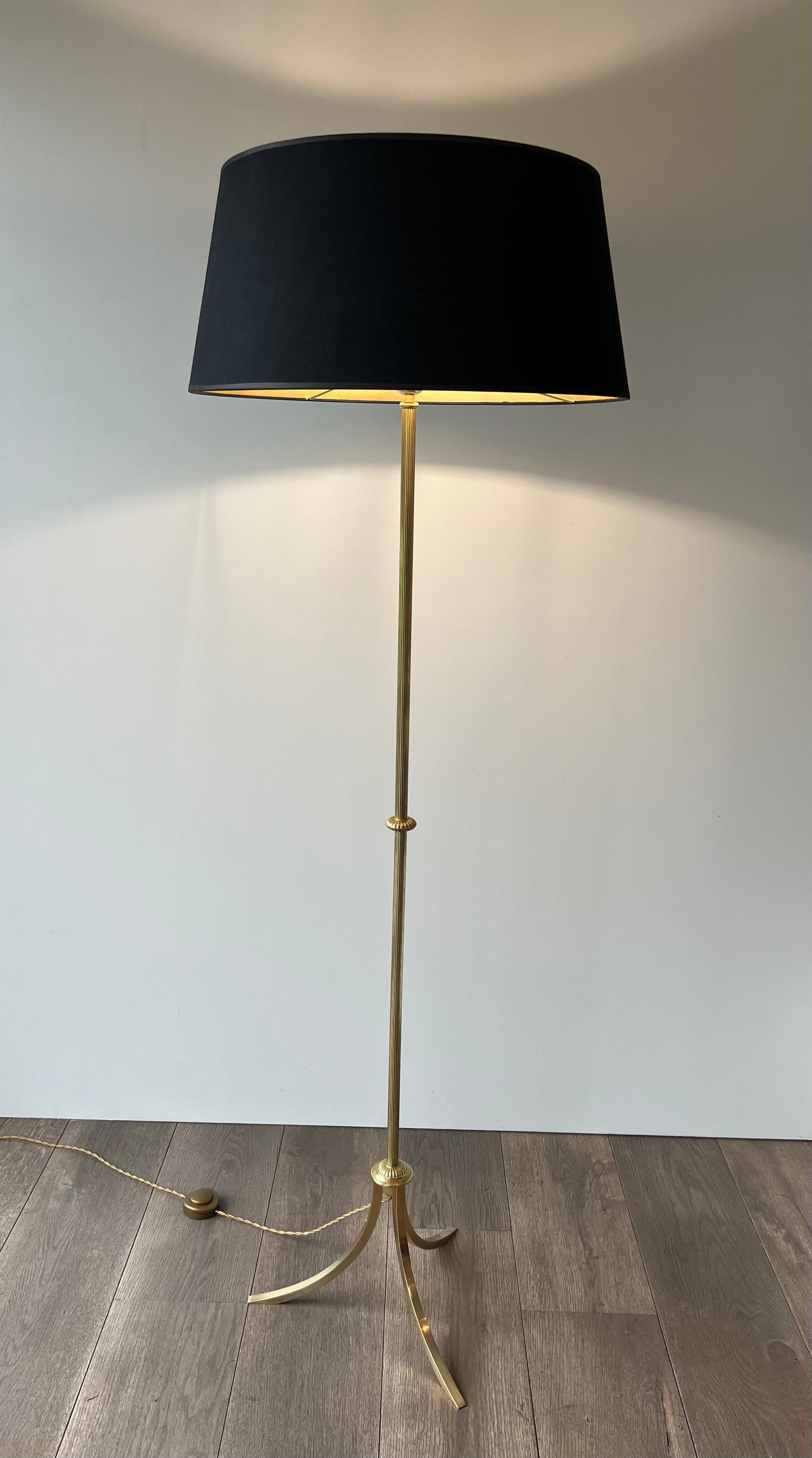 Questa elegante lampada da terra in stile neoclassico è realizzata in ottone con una parte centrale scanalata su una base tripode. Si tratta di un'opera francese attribuita a Maison Jansen. Circa 1940