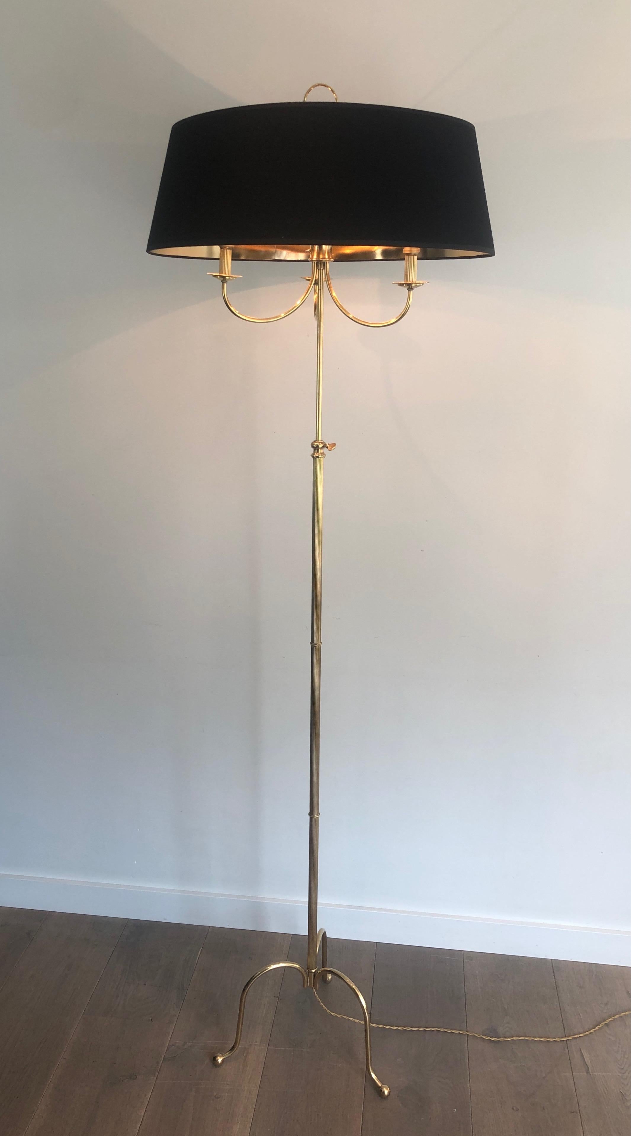 This neoclassical style floor lamp is made of brass. It has 3 arms and is adjustable. This is a French work in the style of Maison Jansen, circa 1940.