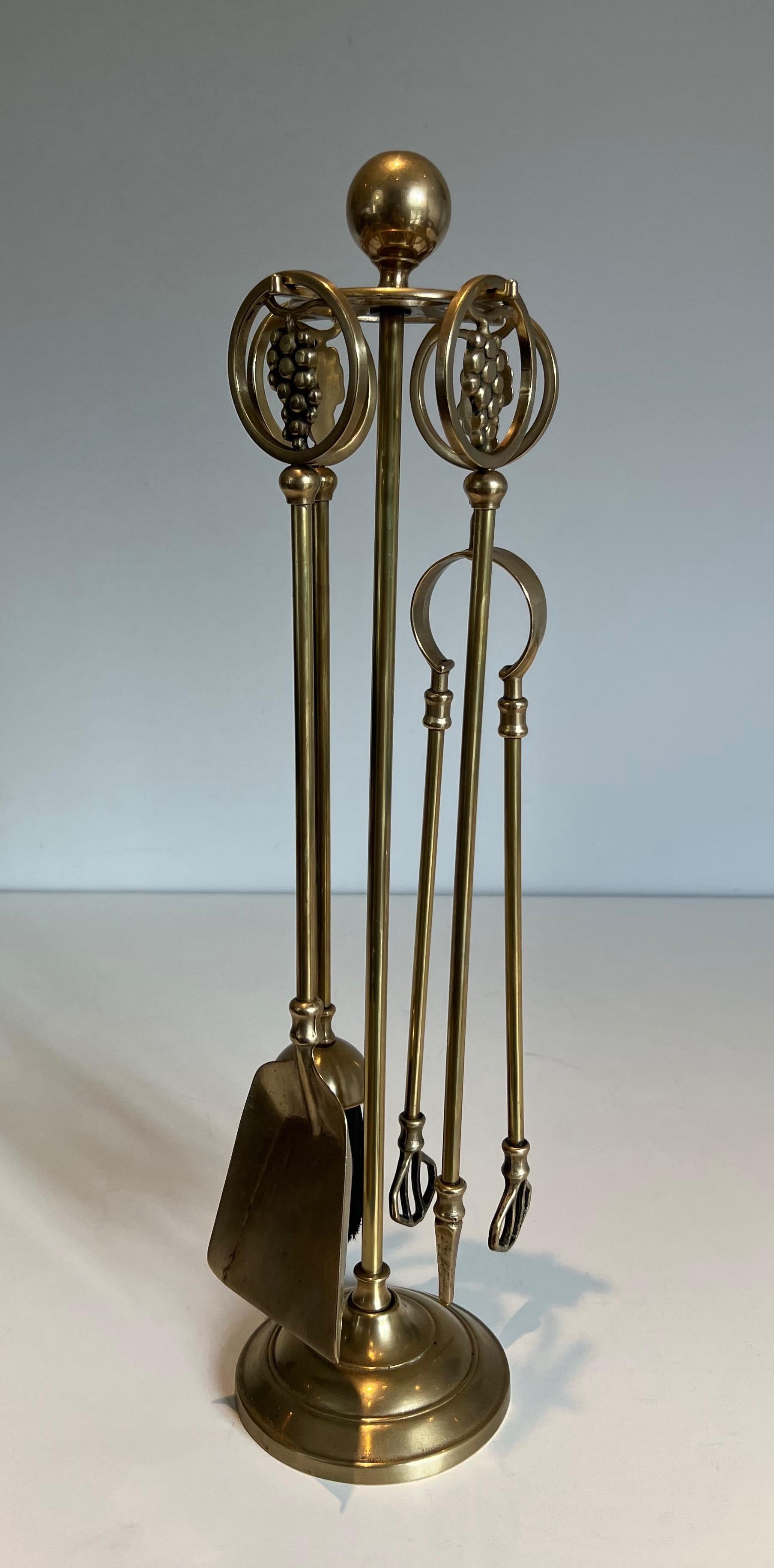 This neoclassical style grappes fireplace tools is made of brass. This is a French work. Circa 1950.