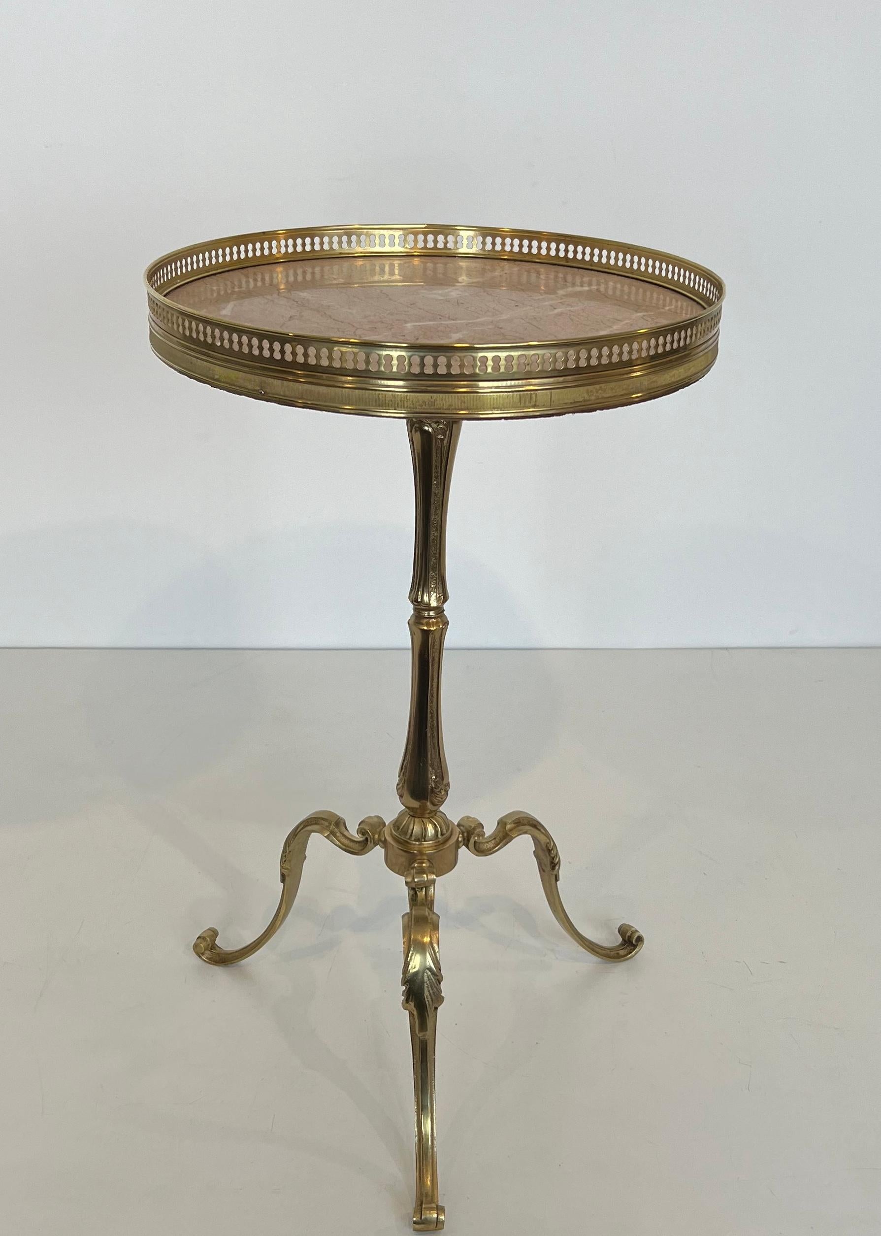 This nice and elegant neoclassical style round gueridon is made of brass with a white marble top. This is a French work attributed to Maison Jansen. Circa 1940