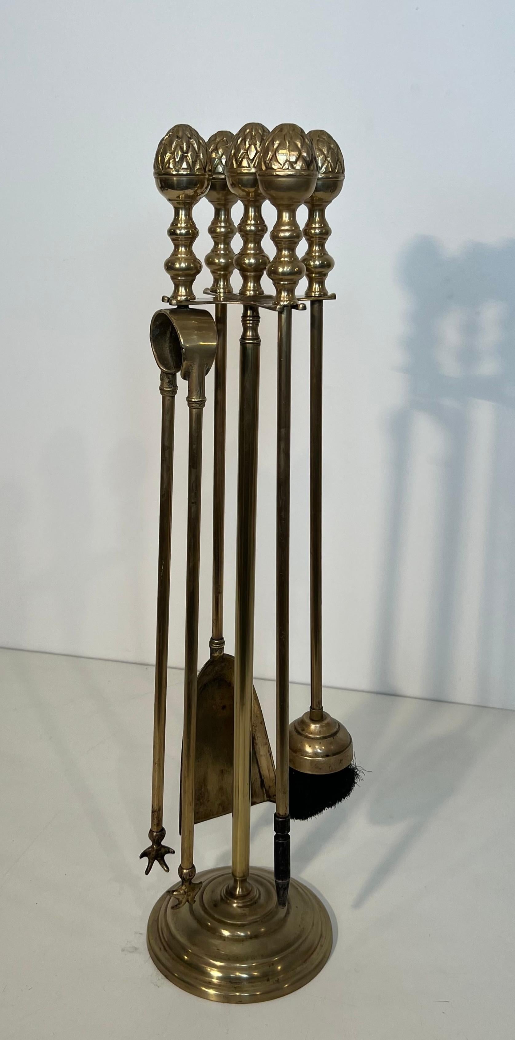Questo simpatico ananas da camino in stile neoclassico è realizzato in ottone. Si tratta di un'opera francese nello stile della Maison Baguès. Circa 1970