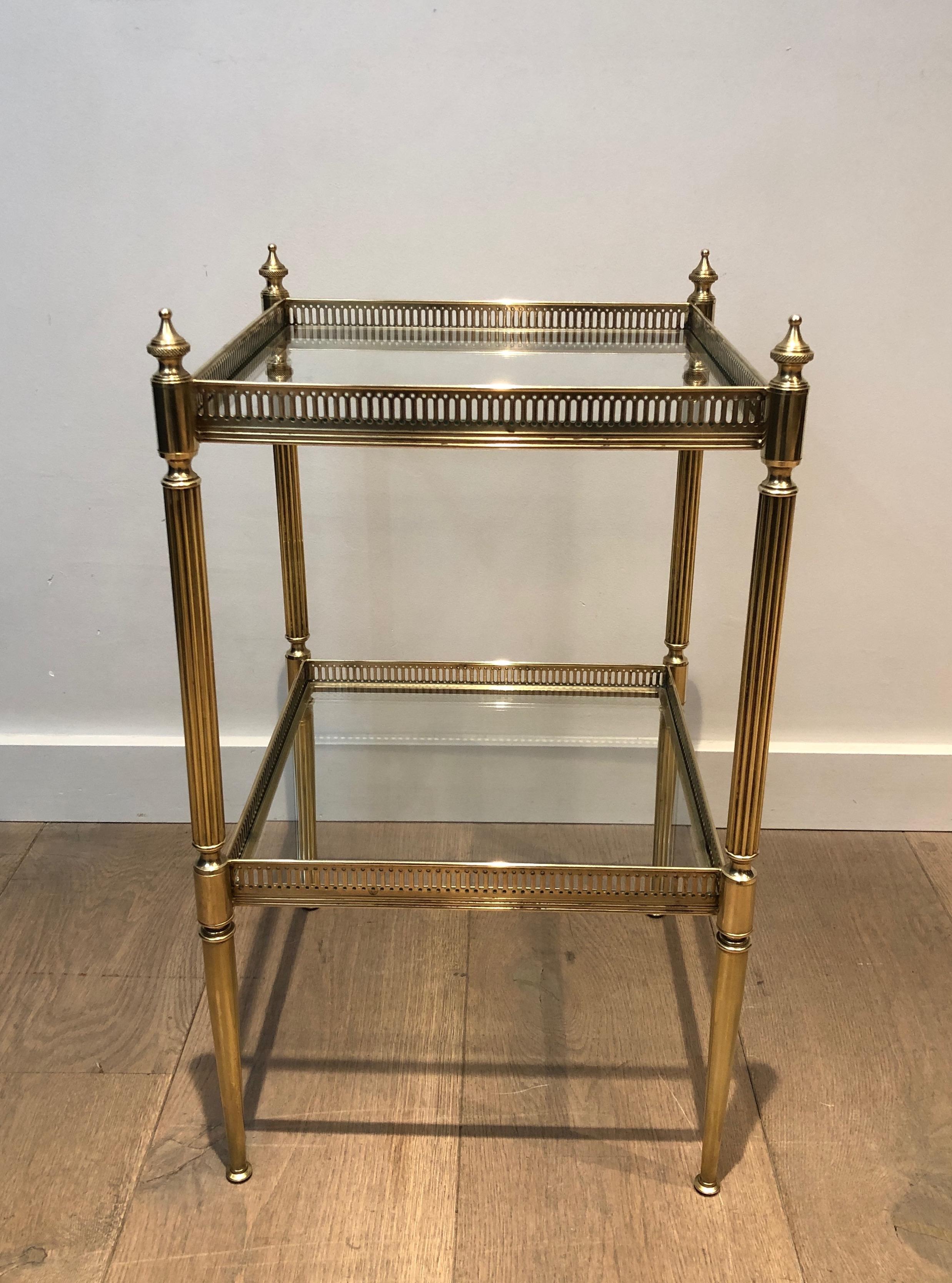 This neoclassical style side table is made of brass with glass shelves. This is a French work by famous French house Maison Jansen. Circa 1940.
  