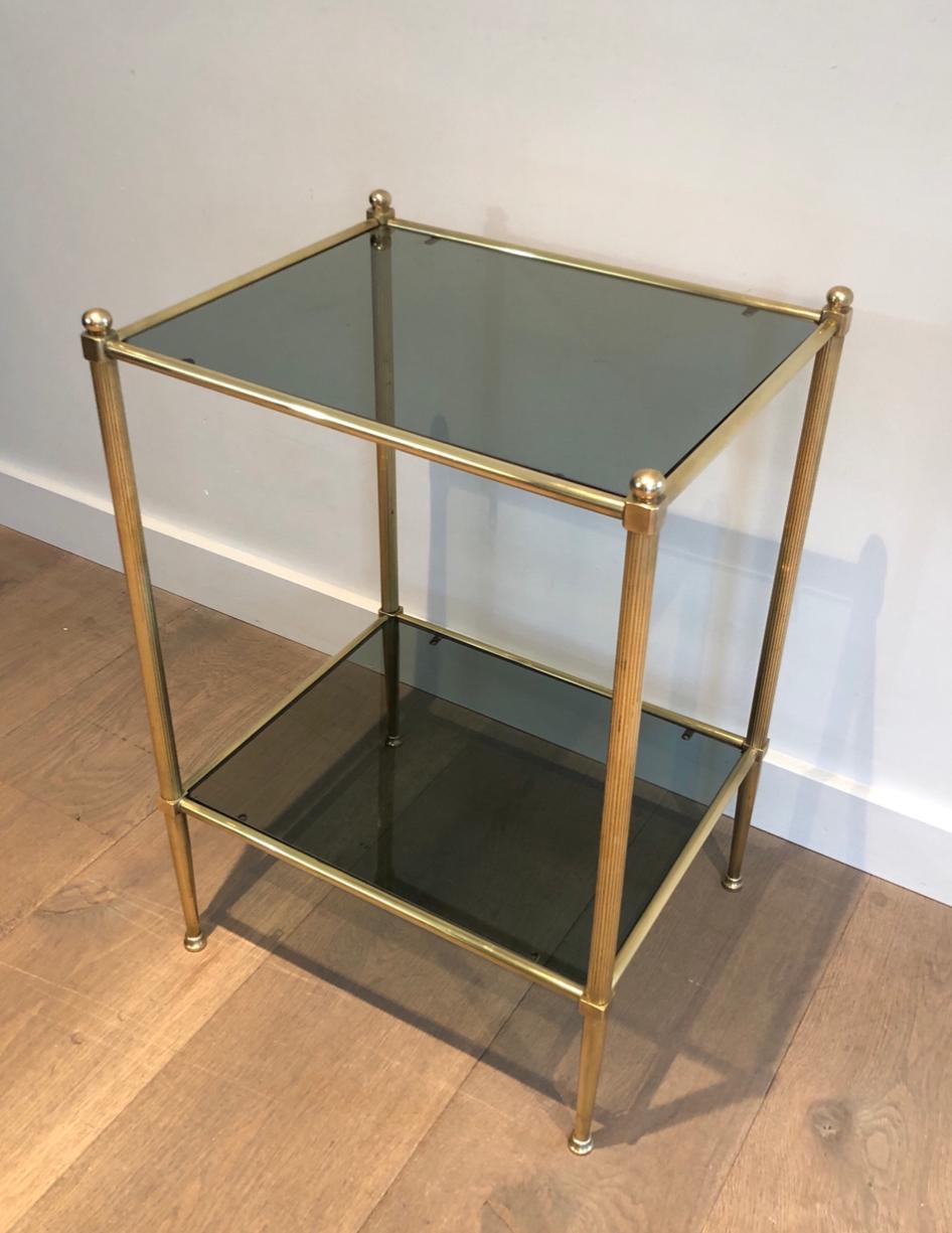 This neoclassical style side table is made of brass with 2 glass shelves. This is a very fine work. in the style of famous designer Maison Jansen, circa 1940.