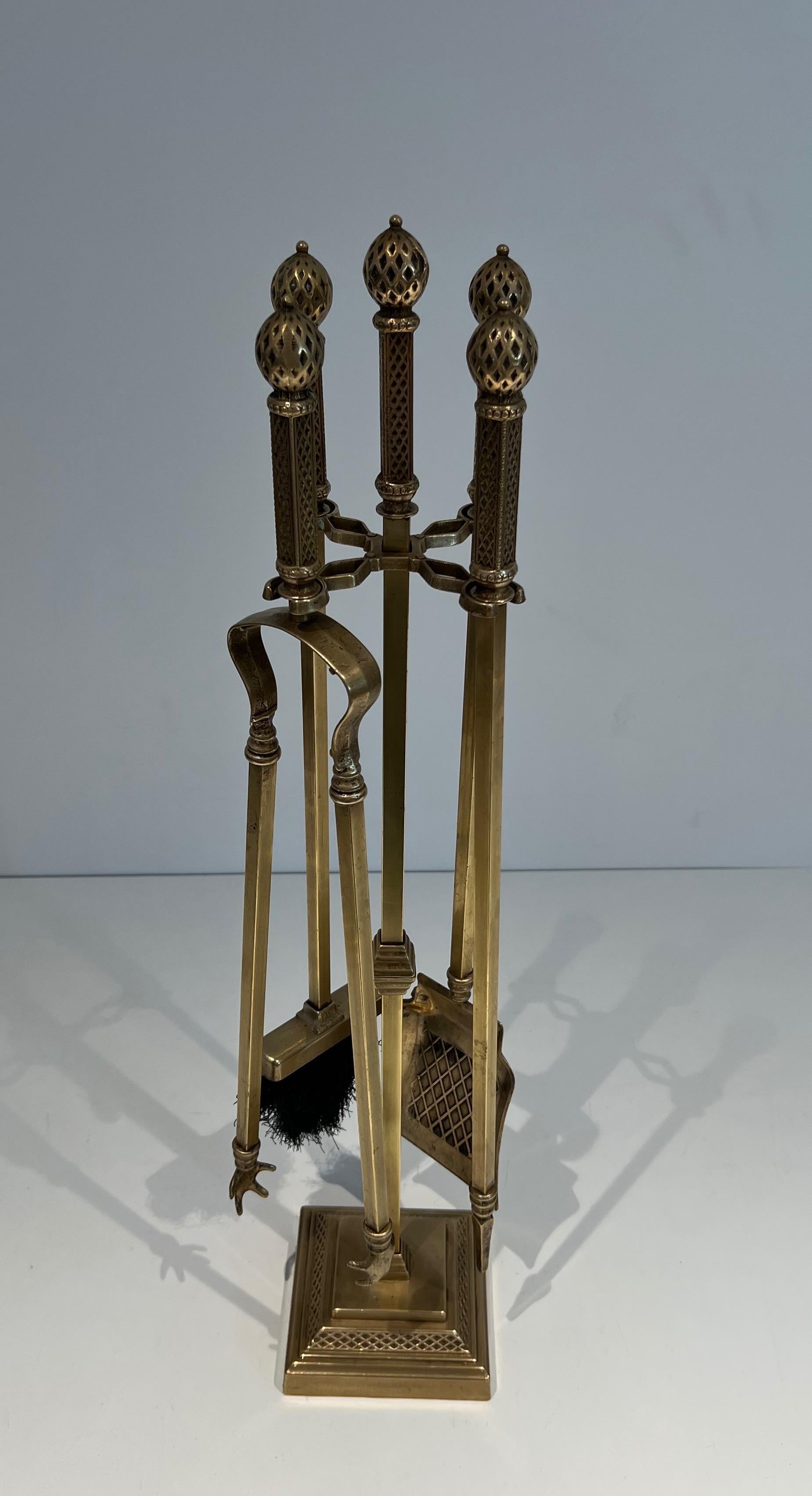 This unusual neoclassical style fireplace tools on stand is made of bronze and brass. The quality of this set is very nice and each element is finely chiseled. This is a French work. Circa 1930