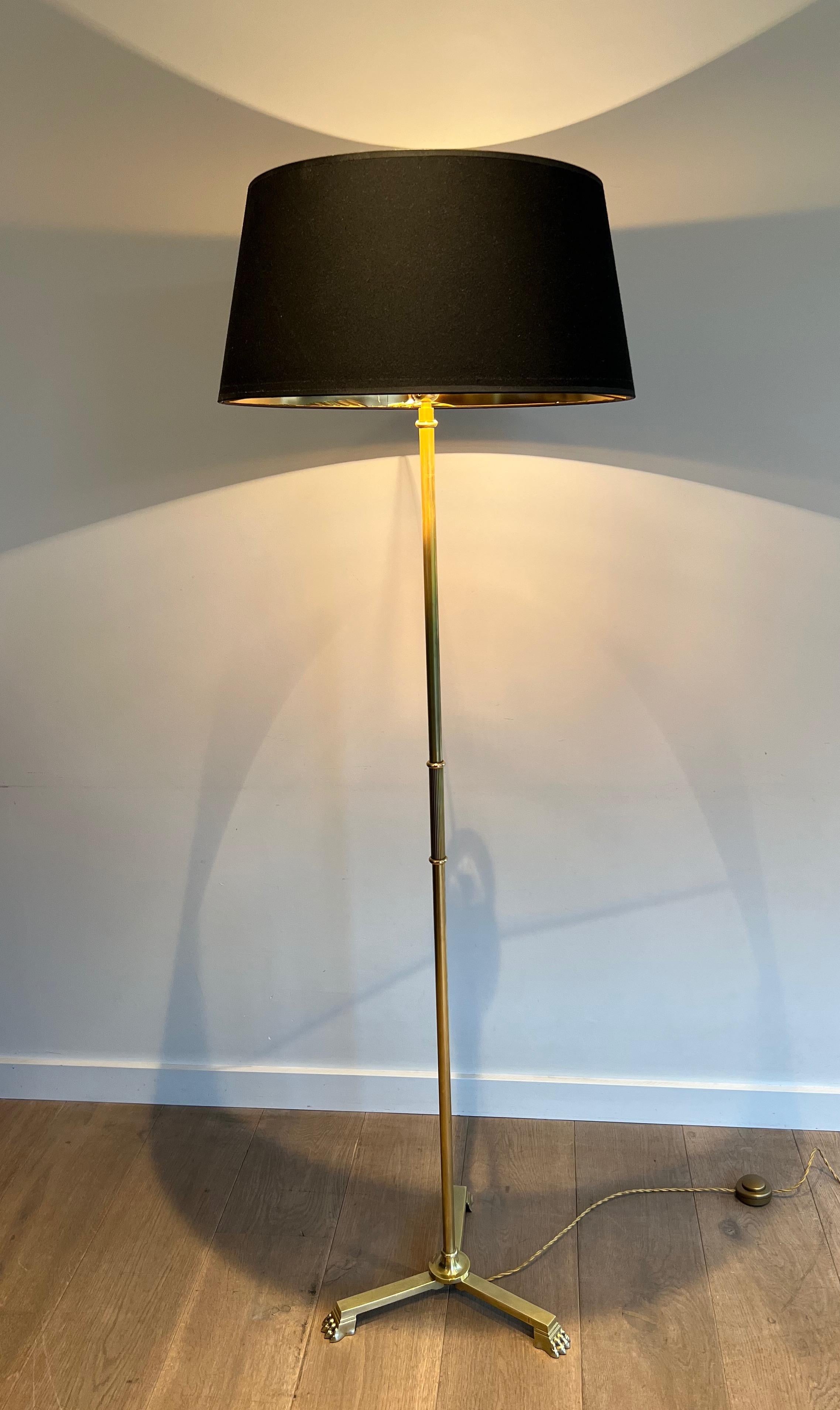 This neoclassical style floor lamp is made of bronze and brass with claw feet. This is a French work by Guy Lefevre for Maison Jansen. Circa 1940