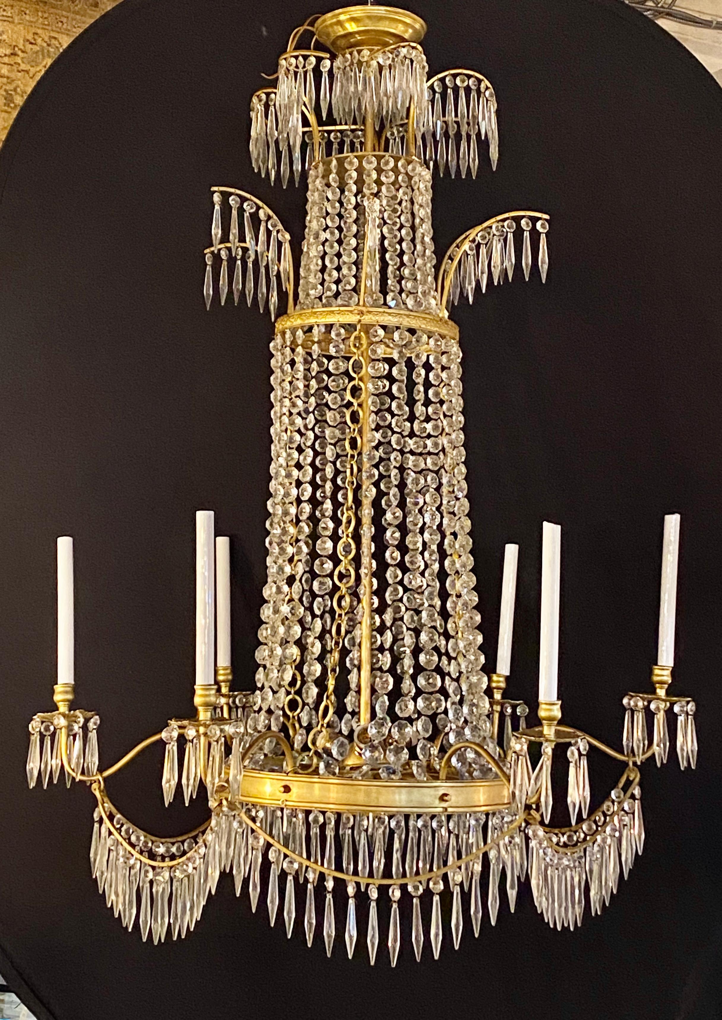 Pair of neoclassical style bronze and crystal monumental chandeliers. Seemingly timeless is this elegant and sophisticated Russian neoclassical look. The pair having wonderfully placed finely cut crystals on a bronze support. Each having been