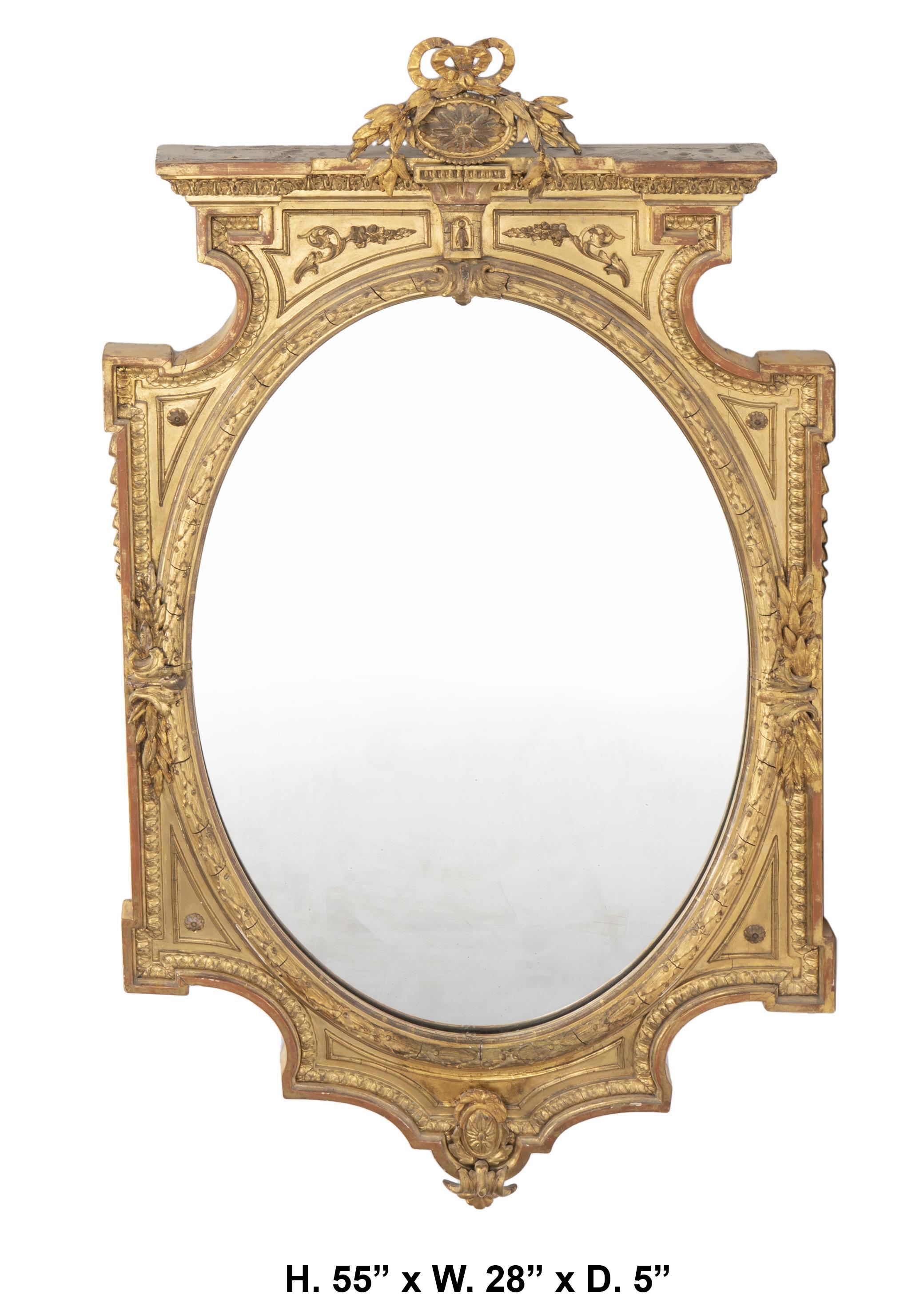 Uniquely shaped 19 century Italian neo-classical style gilt wood and gesso mirror.
The carved cornice with a floral medallion topped with ribbon details atop a carved elaborate frame adorned with applied composition moldings and foliate designs