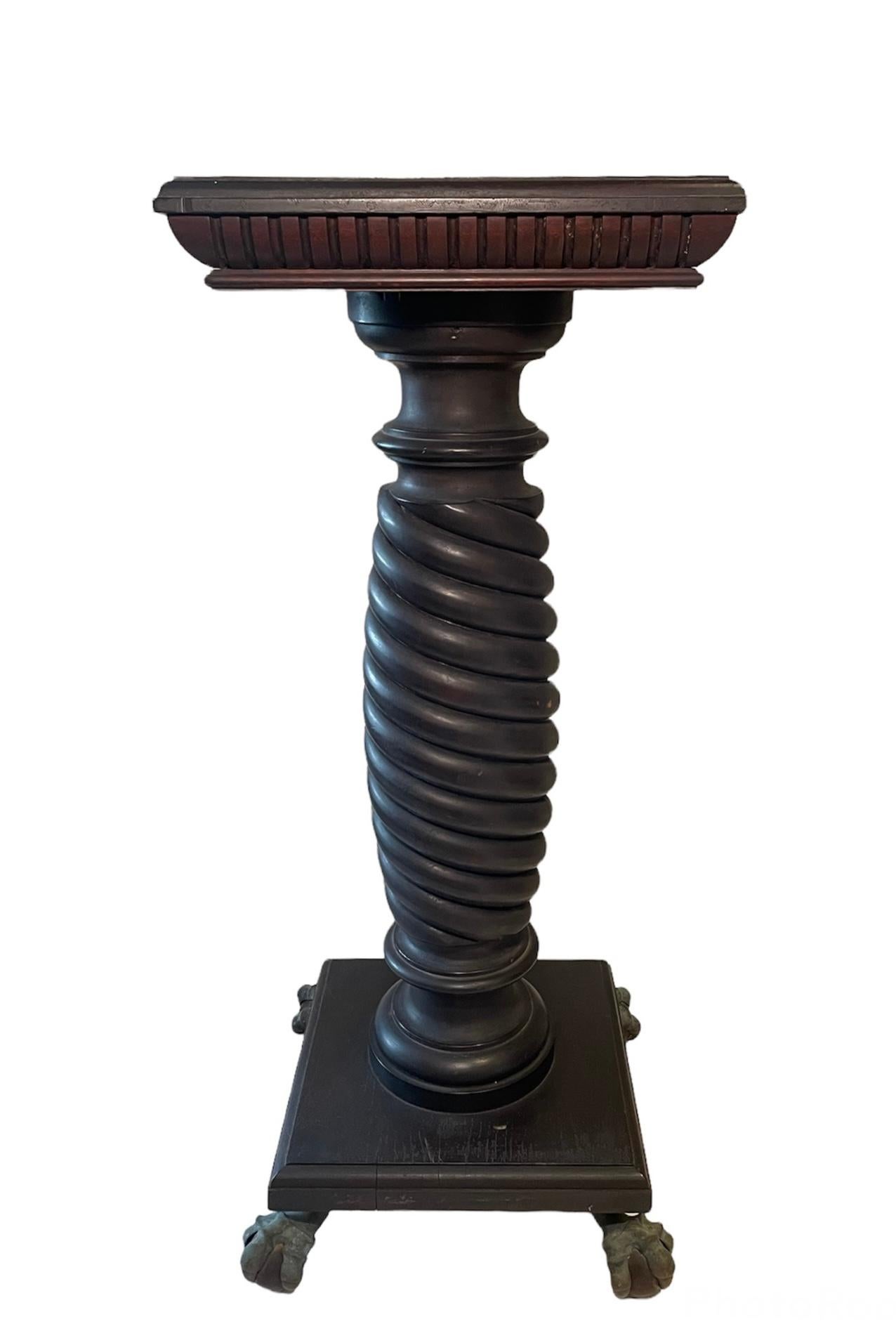 This is a very tall and heavy spiral carved dark solid wood column. It depicts a square top adorned with fluted side borders. This is followed by a spiral carved wide column that ends with a square wood base with four bronze bird talons and wood