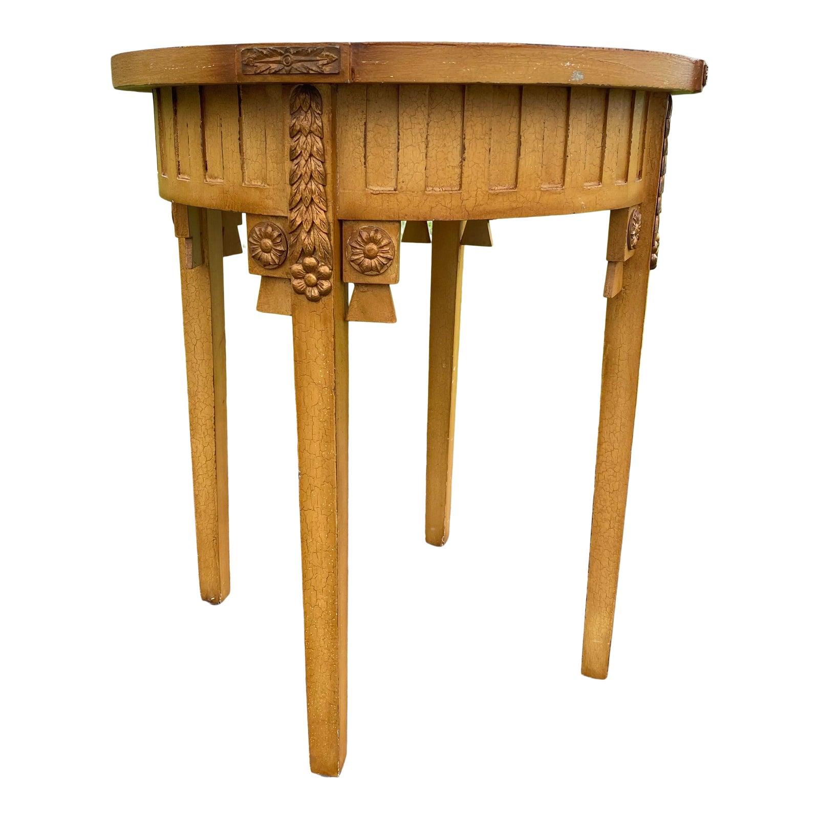 Neoclassical style tall round table featuring decorative medallions and botanical carvings highlighted by gilt accents. Can be used as a center table or a tall side end table. This four legged table has a glazed textural crackle finish.

Please