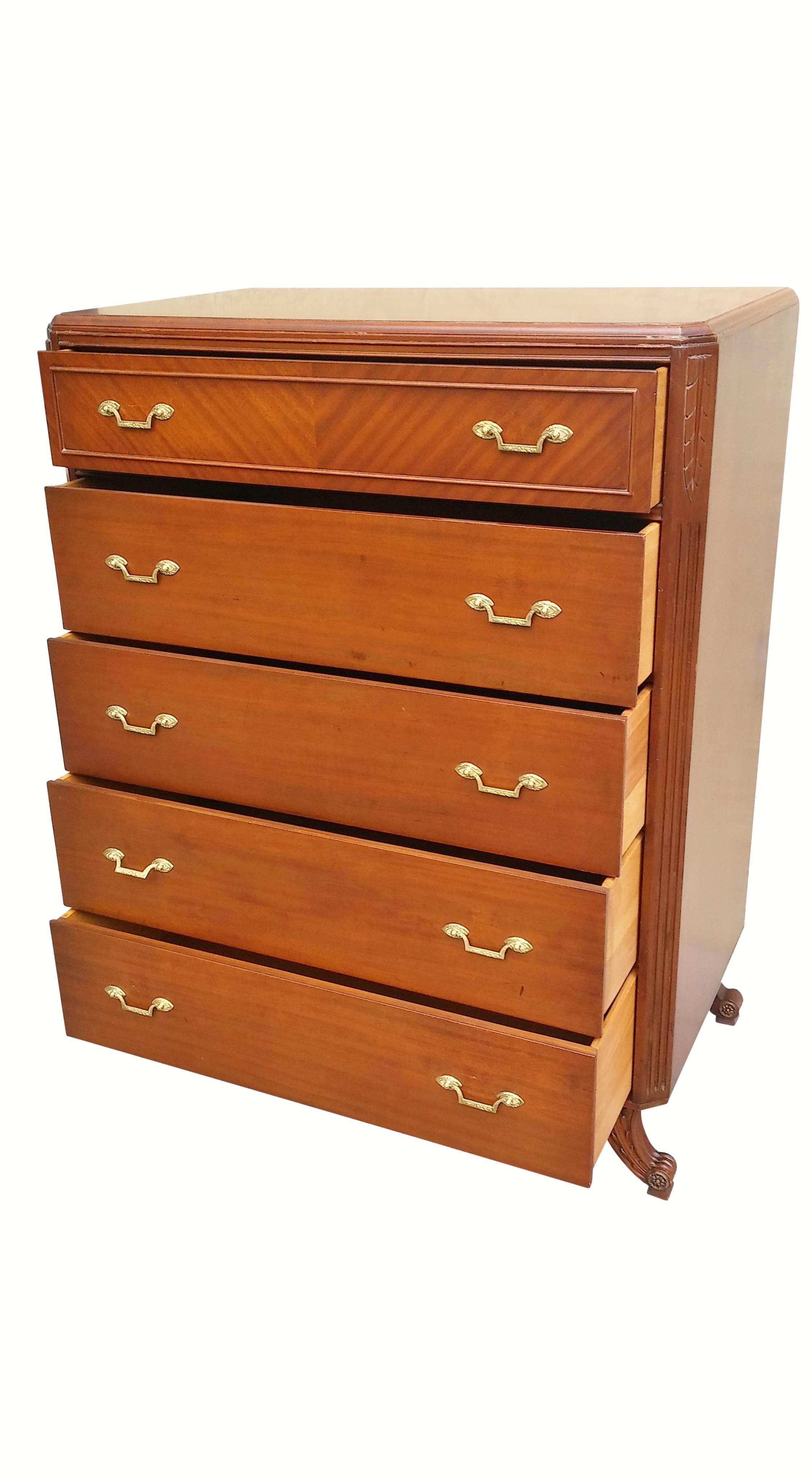A Neoclassical style chest of drawers made by Rway Northern Furniture Company of Sheboygan, Wisconsin. Made of mahogany, five dovetailed drawers open with squared brass handles. The top drawer has a tiger mahogany front panel and a central divider