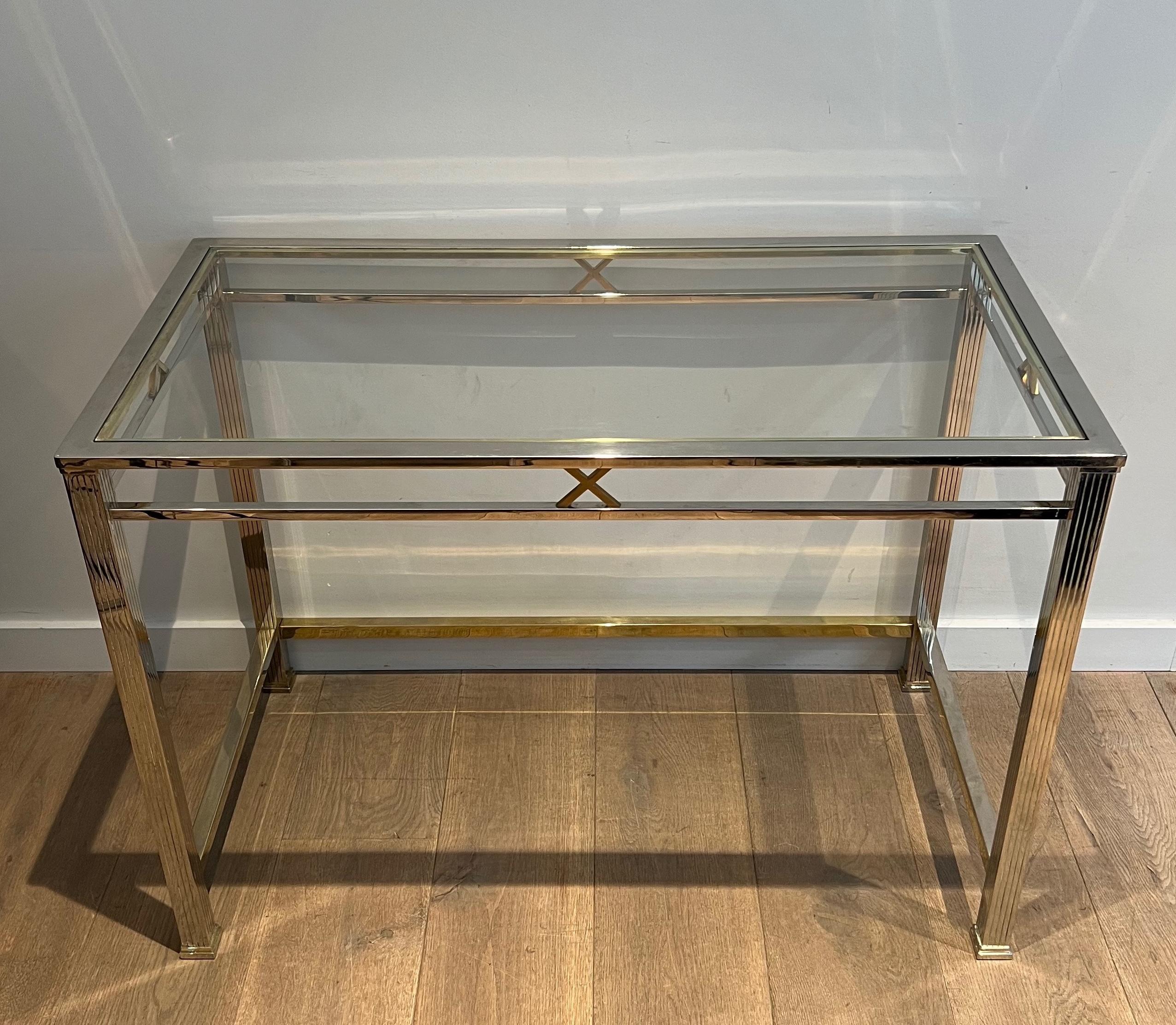 This very nice and chic neoclassical style desk is made of chrome and brass. The desk has fluted legs and brass crosses decorated the piece all around the top part. This is an Italian work. Circa 1970