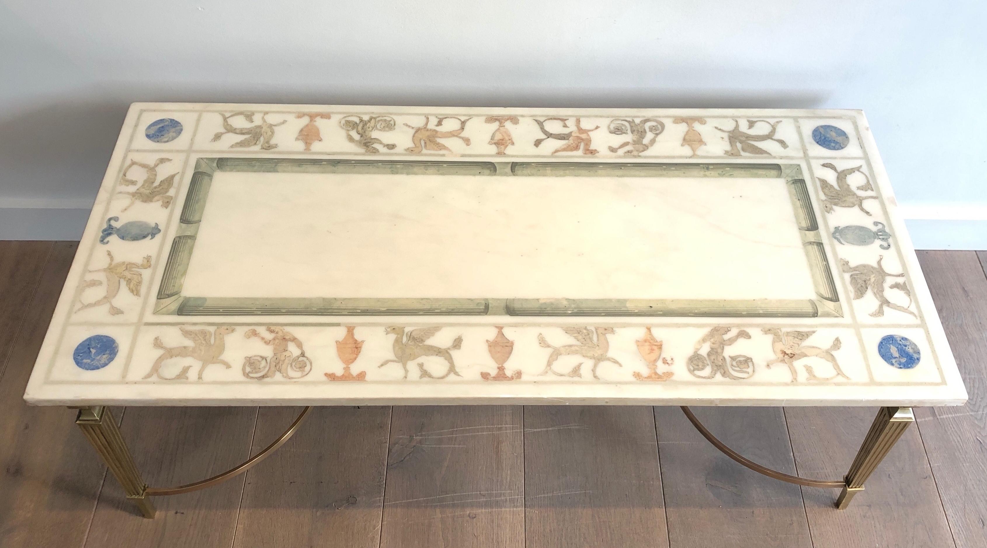 Esta mesa de centro de estilo neoclásico, muy bonita y única, está hecha de bronce y latón con una tapa de mármol blanco decorada con motivos griegos. Se trata de una obra francesa. Alrededor de 1940