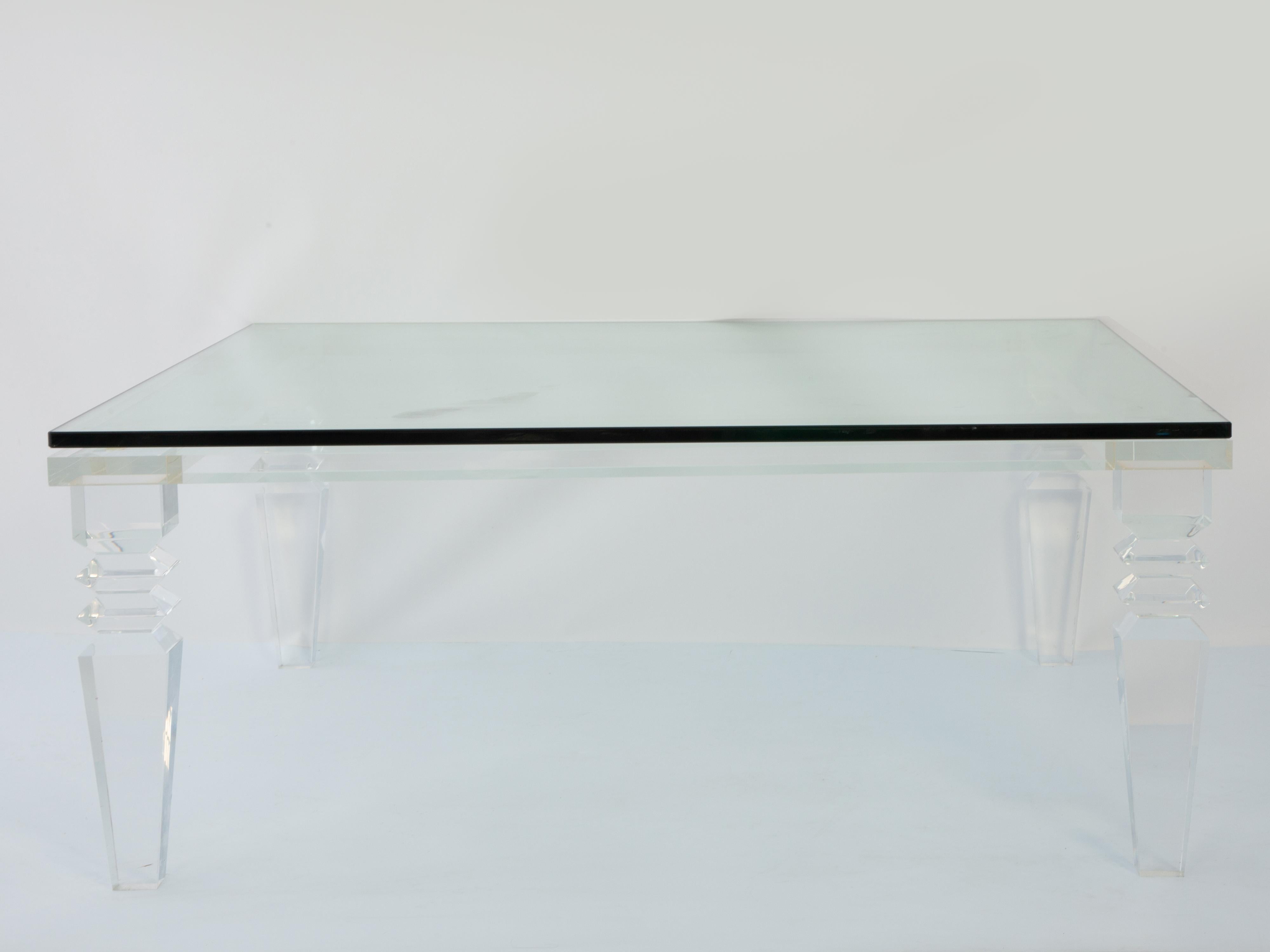 Coffee or cocktail table, having a square top of glass, on a frame of extruded Lucite, raised on tapering, square-sectioned legs with knopped decoration. 

Stock ID: D3944 