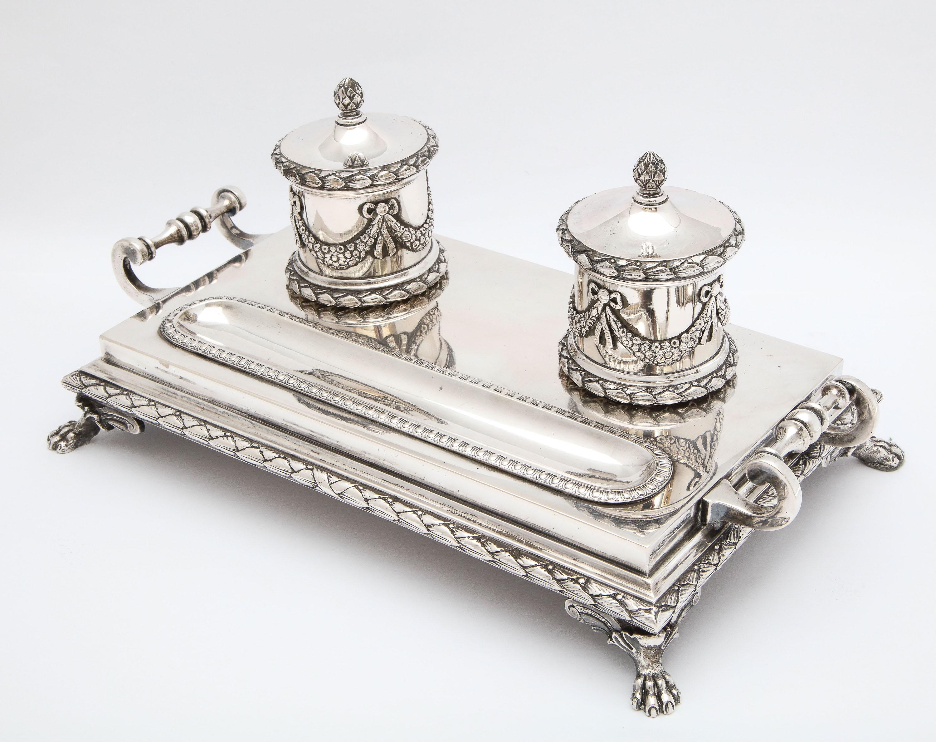 Neoclassical - style, Continental Silver (.800), footed, double inkstand, Denmark, year-hallmarked for 1901, A. N. Dragsted - maker. Each of the wells is decorated with bows and garlands. Measures 10 3/4 inches wide (from handle to handle) x 6