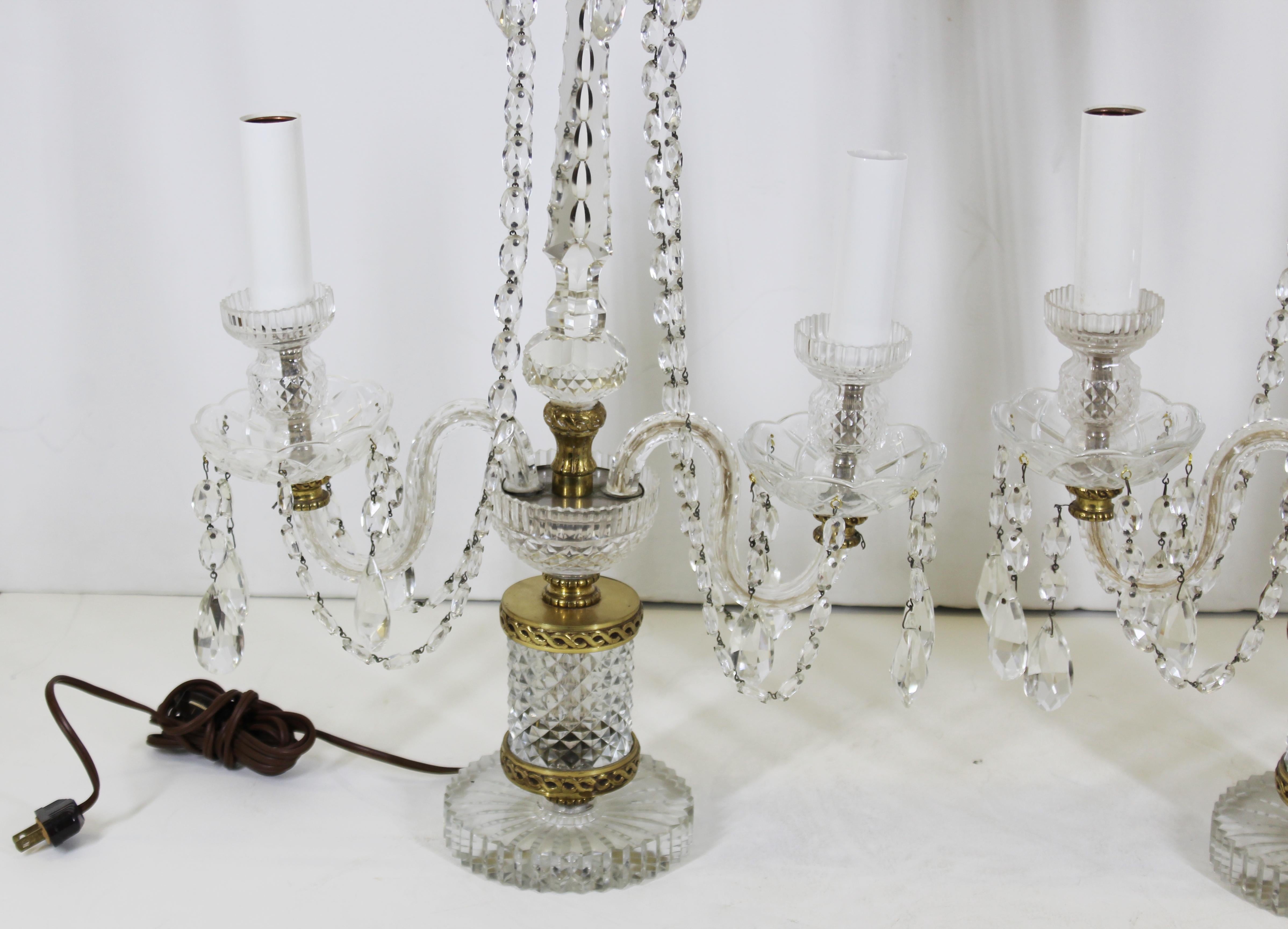 Neoclassical style pair of crystal lamps with droplets and gilt metal elements. The pair was made in Czechoslovakia likely around the mid-20th century. In great vintage condition with age-appropriate wear and use.